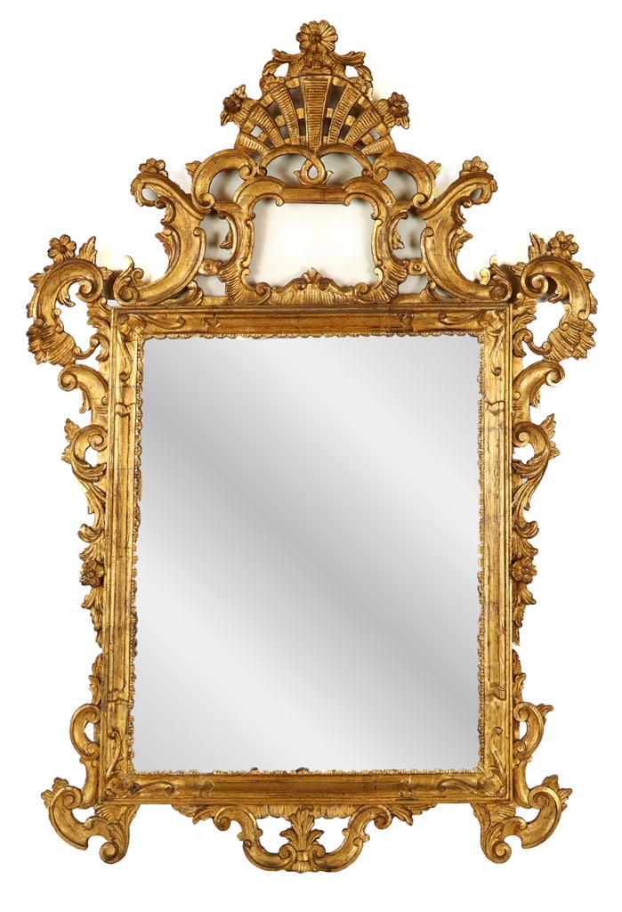 Carved and Giltwood Rococo Mirror: Carved and giltwood Rococo Mirror, Italian, 19th century, with a floral decorated upper, and elaborate carved and gilt frame. [54" H x 37" W]. Condition is good with some minor losses to gilding, glas