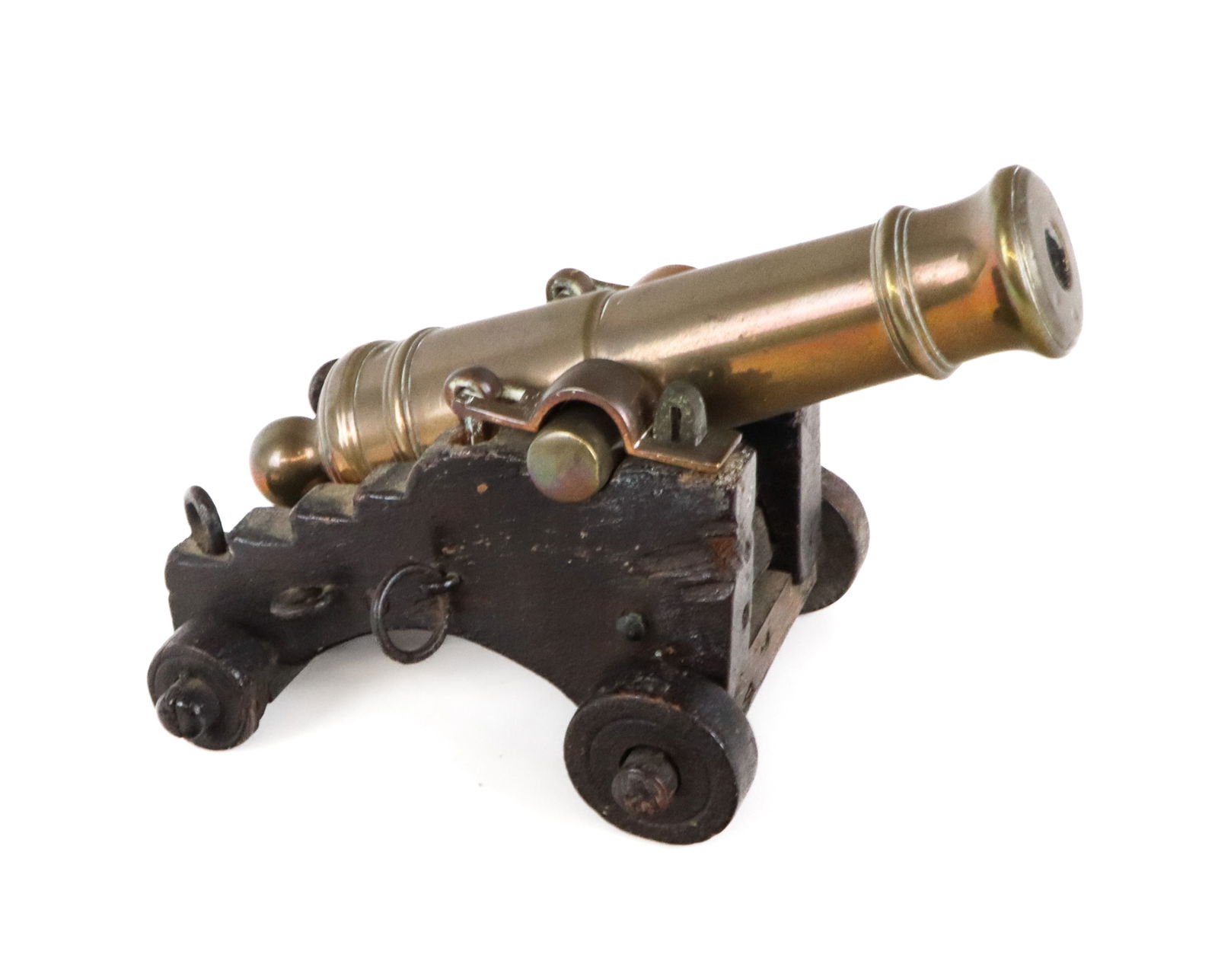 Bronze Diminutive Cannon: Bronze diminutive cannon with wooden wheels and frame, probably late 19th century. [5" H x 5" W x 8" D]. Overall all condition is good, some warping and cracking to wood. Estate of Priscilla and Byam
