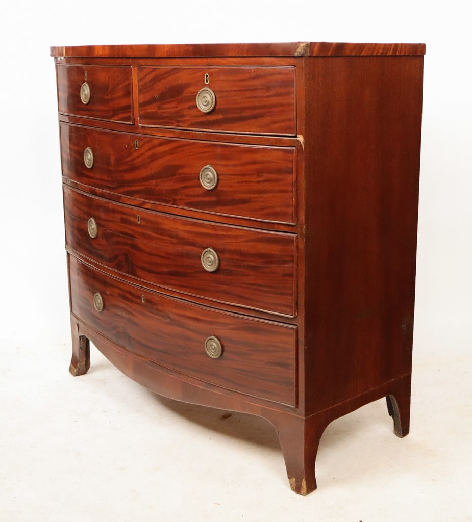 George III Mahogany Bow Front Chest: George III mahogany bow front chest of drawers, late 19th century, with two short and three long cockbeaded drawers and splayed feet. [42" H x 41" W x 21" D]. Overall condition is fair, with losses, s