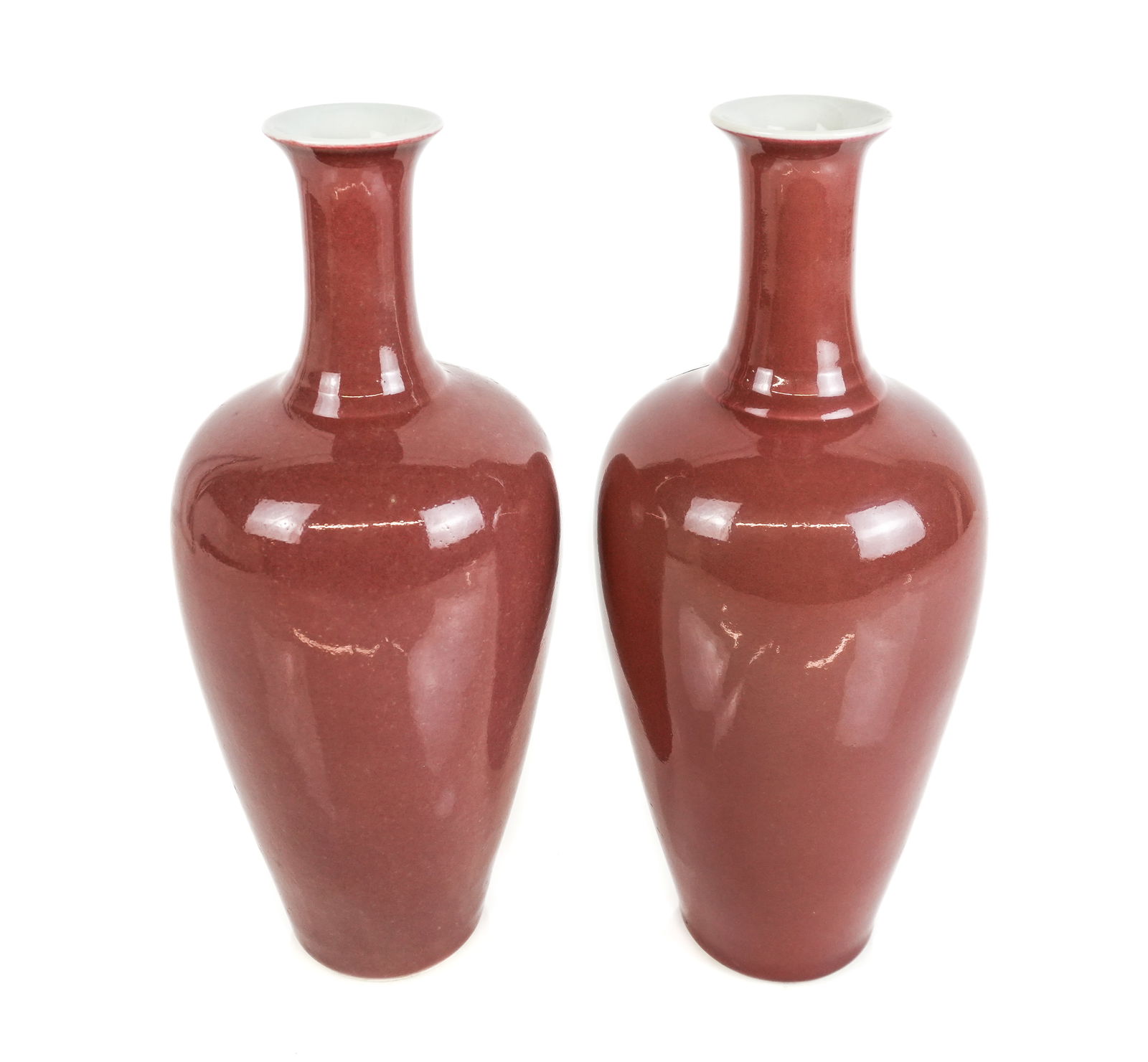Chinese Pair of Sang de Boeuf Baluster Vases: Pair of Chinese sang de boeuf oxblood baluster vases, 19th century, one with a blue glazed decoration at base, otherwise unmarked. [12" H x 5" Diameter]. Condition is good. LOCATED AT 150