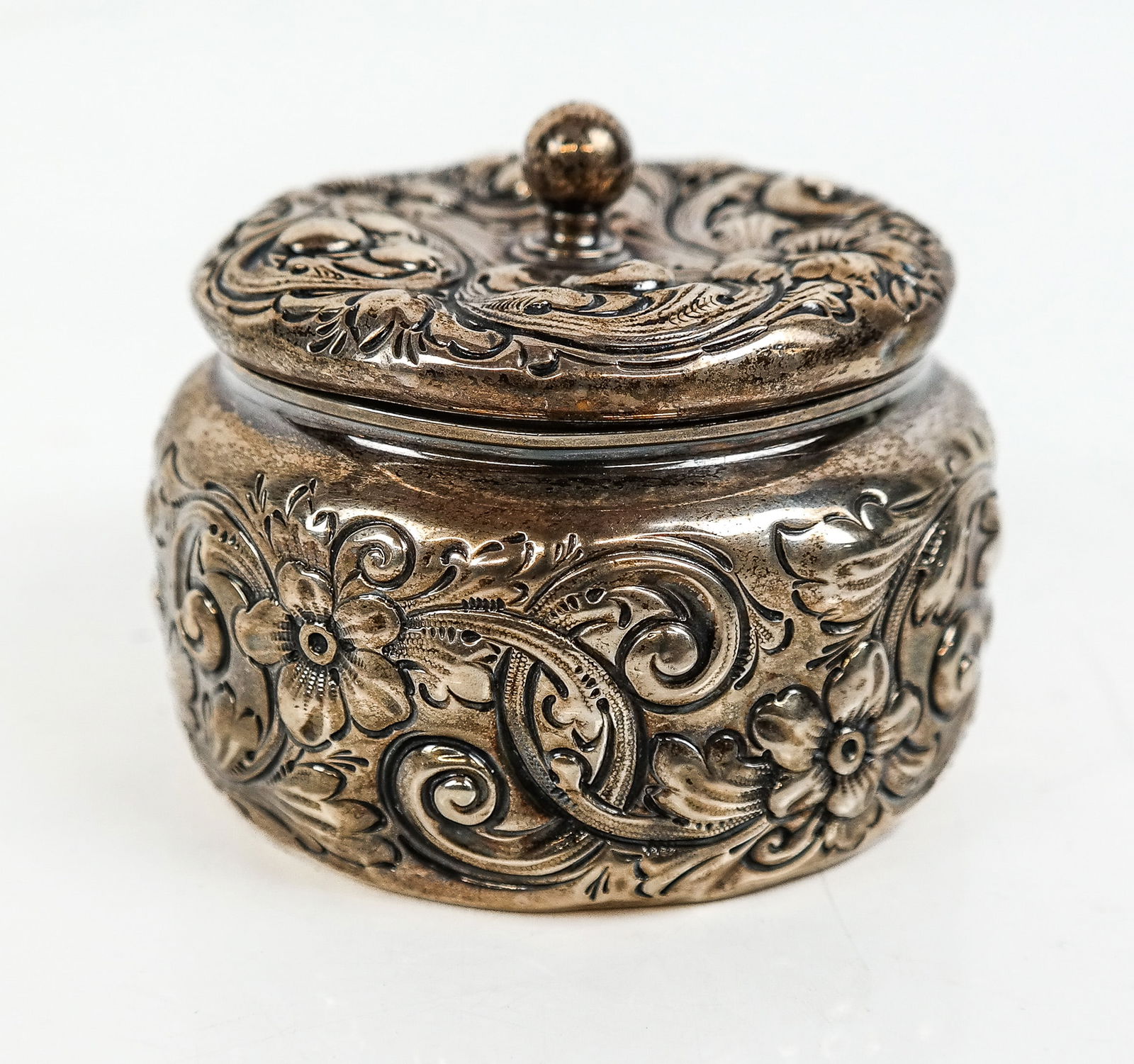 Gorham Sterling Silver Repousse Powder Box: Gorham sterling silver repousse powder box, last quarter of the 19th century, marks to revere. [2 ozt.,.2.5" H x 3.25" Diameter]. Overall condition is good, wear and slight dents most noticeable on ba