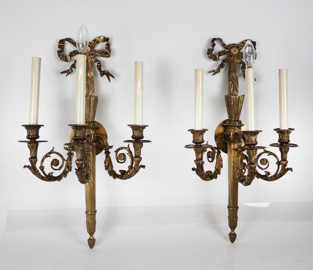 Pair of Louis XVI Gilt Bronze Sconces: Pair of Louix XVI gilt bronze three light wall sconces, probably late 19th/early 20th century, with a ribbon, quivers and fabric standard and scrolling foliage arms with grape accents, marks to