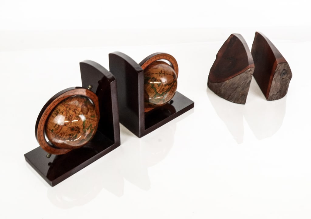 Two Pairs of Wooden Bookends: Two pairs of wooden bookends comprising a pair of mid-20th century live-edge bookends with a lacquer finish, and a pair of 21st century bookends with globe decoration. [Globe bookends: 7.25" H x 6.5"