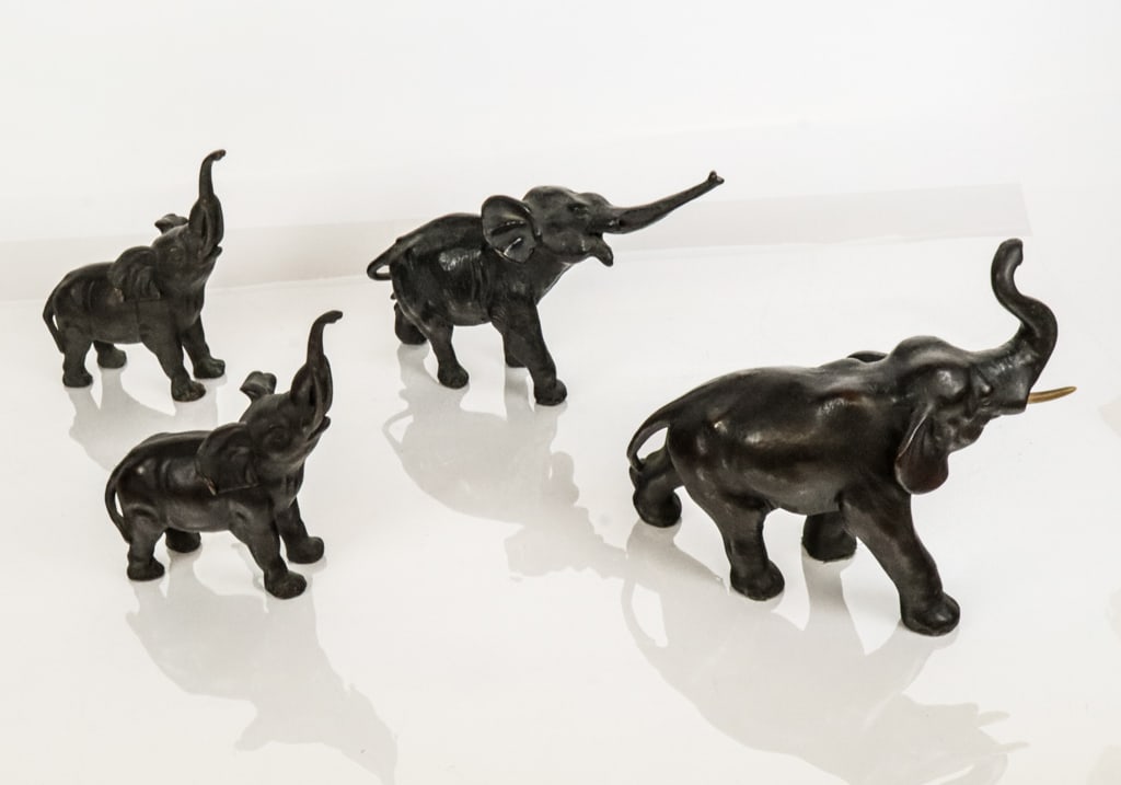 Four Bronze Elephants: Four bronze elephants, 20th century, comprising a matched pair of smaller elephants, and two larger elephants, the largest with inset faux ivory tusks. [Largest: 9.25" H x 9.5" W x 4.5" D]. Condition