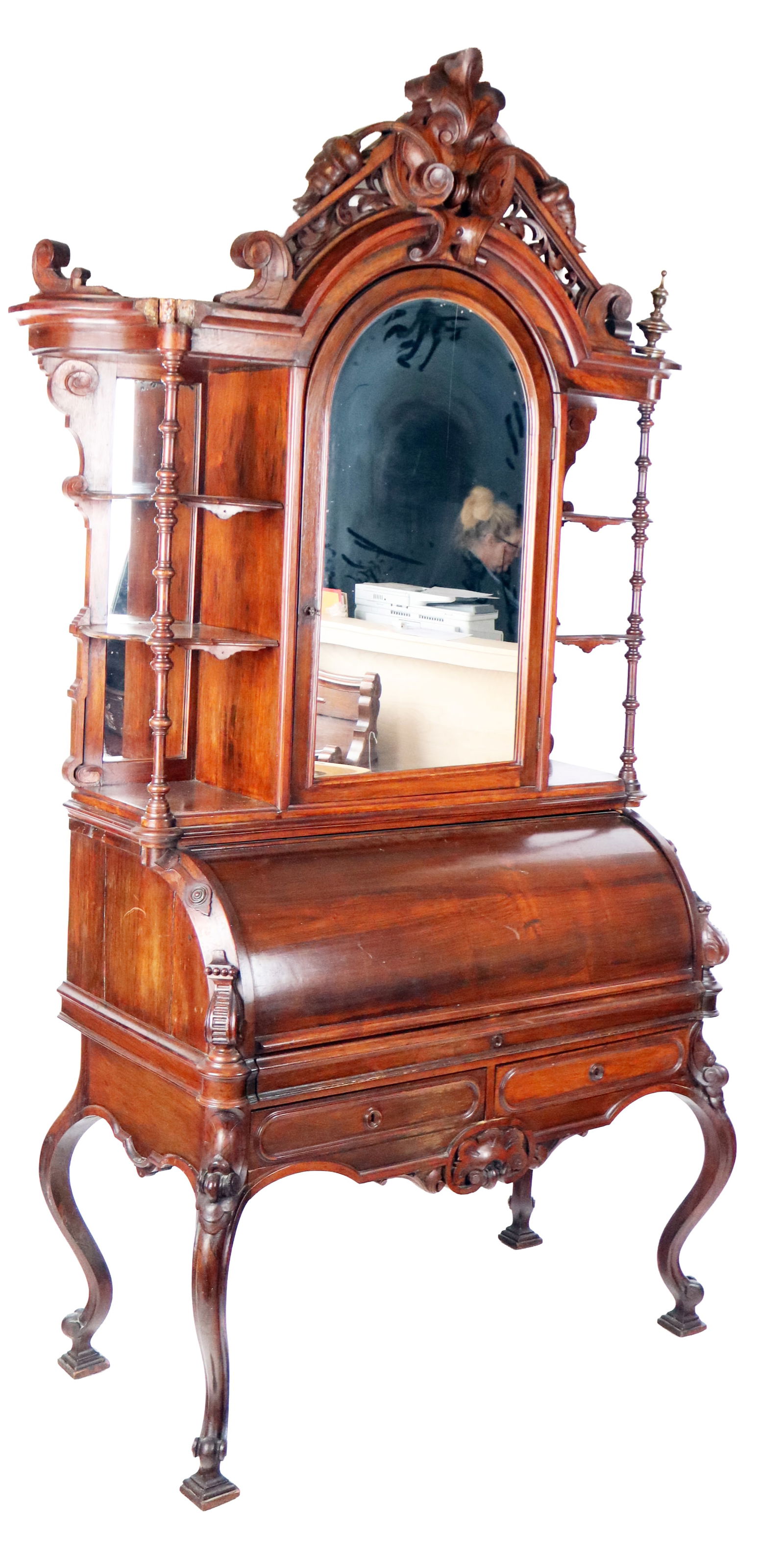 Belter Victorian Cylinder Front Secretary: John Henry Belter manner carved rosewood and mahogany barrel front secretary, mid-20th century, with a bellflower pediment over a mirror flanked by open shelves with a roll top desk opening to reveal