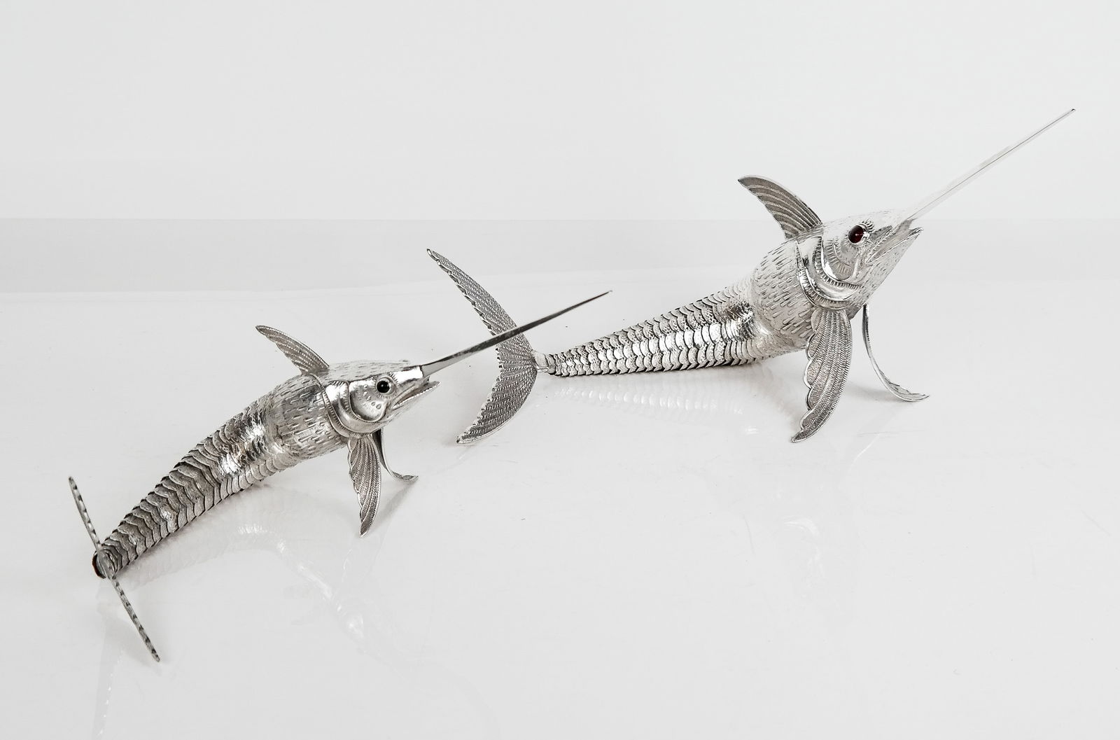 Two Spanish Silver Fish Table Ornaments: Two Spanish silver .915 quality and faux gemstone articulated swordfish table ornaments, marks to fins including fins and makers mark. [Total: 16.5 ozt.; Largest: 4" H x 18.5" L x 2.5" W]. Overall con