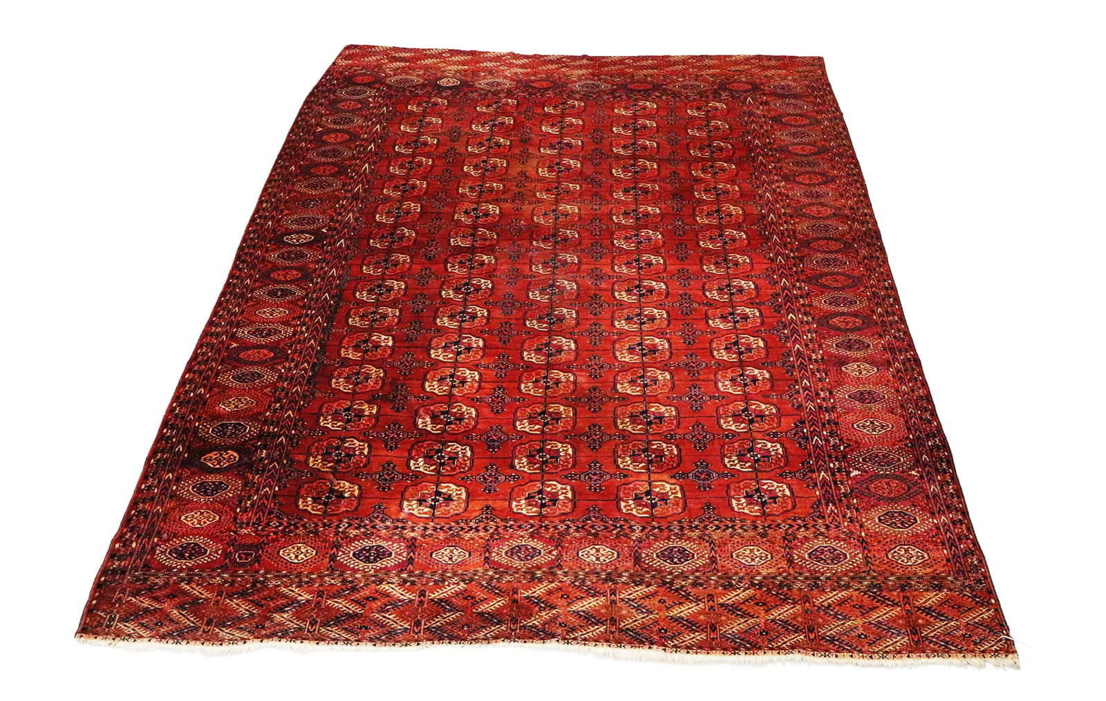 Oriental Carpet (Bokhara): Bokhara Oriental carpet, in classic reds with repeating double rosette pattern with rosette border. [8' (96") x 10'9" (129")]. One end with slight losses, otherwise in good condition, and soft.