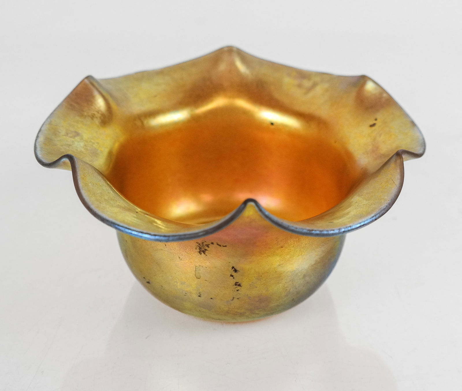 Steuben Aurene Glass Nut Dish: Stueben Aurene iridescent glass nut dish, early 20th century, with a scalloped edge, marked Aurene to base. [2.5" H x 5" Diameter]. Condition is good with some variation to finish. From the Collection