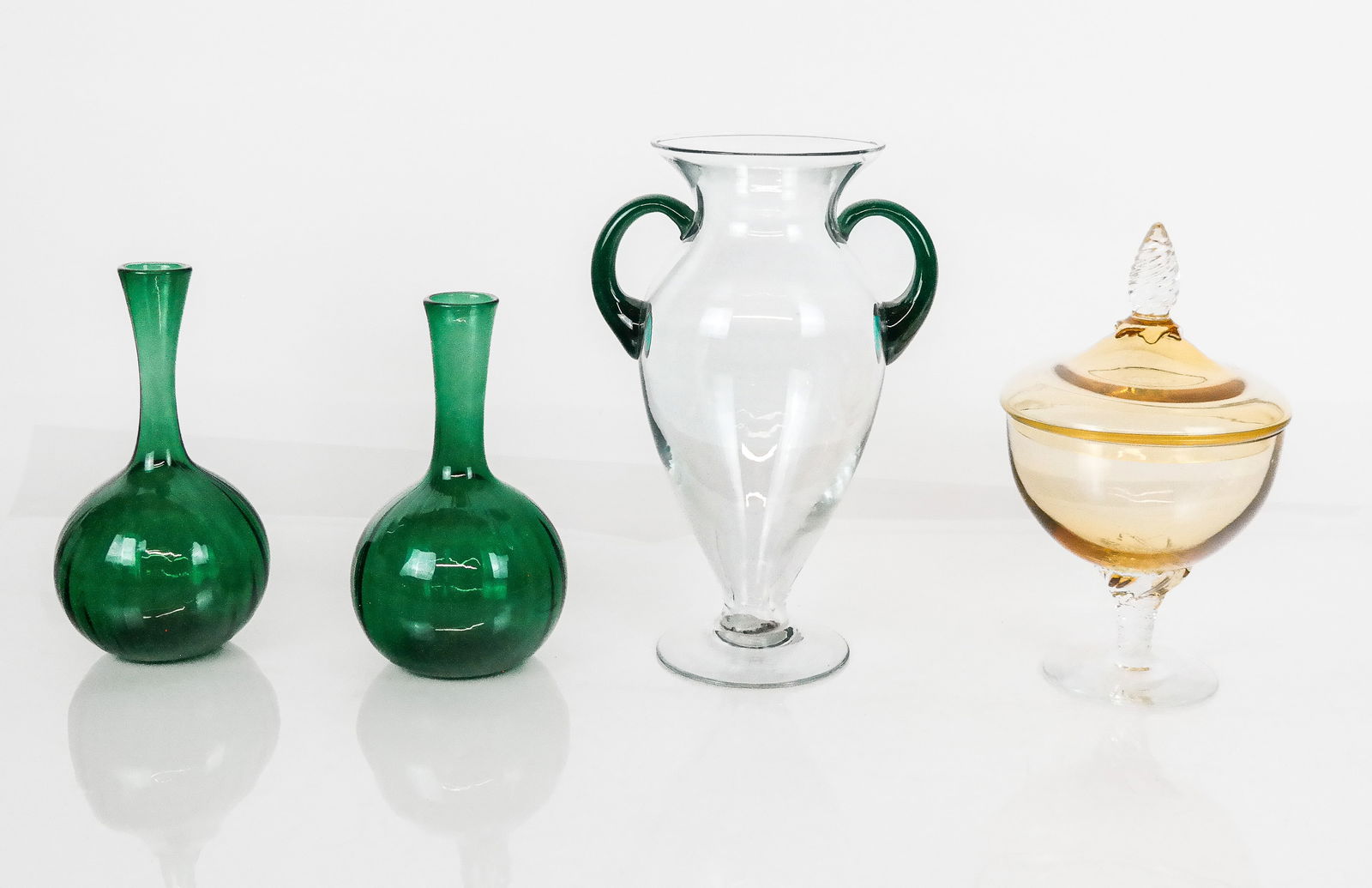 Four Art Glass Articles: Art glass articles comprising a pair of vintage Museum of Fine Art green glass bud vases, each marked MFA, a hand-blown amber glass sweet meat dish with pinecone finial, and a hand-blown amphora form