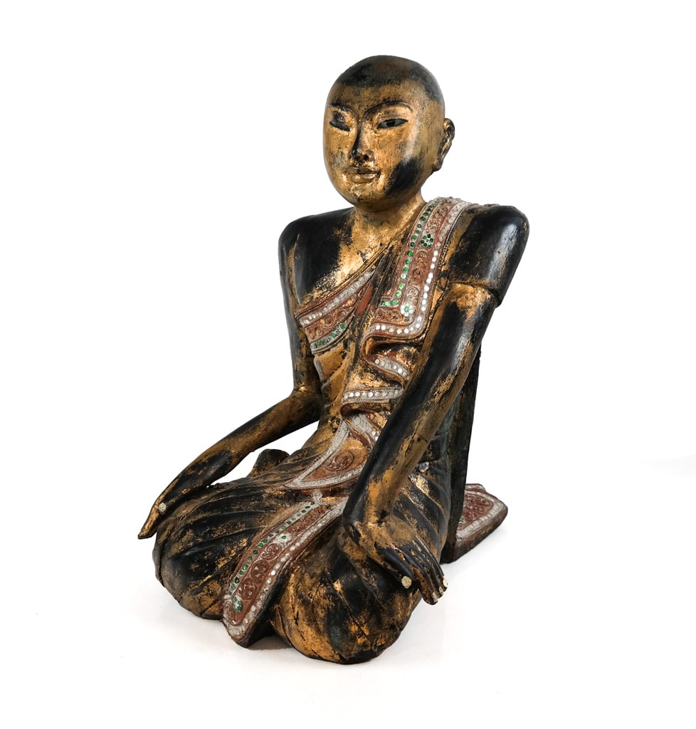 Thai Carved and Gilt Sculpture of a Buddhist Monk: Thai carved, gilt and polychromed sculpture of a Buddhist monk, Thailand, 19th century, with the figure seated on a base, with inset colored glass details. [19" H x 14" W x 18" D]. Condition is good