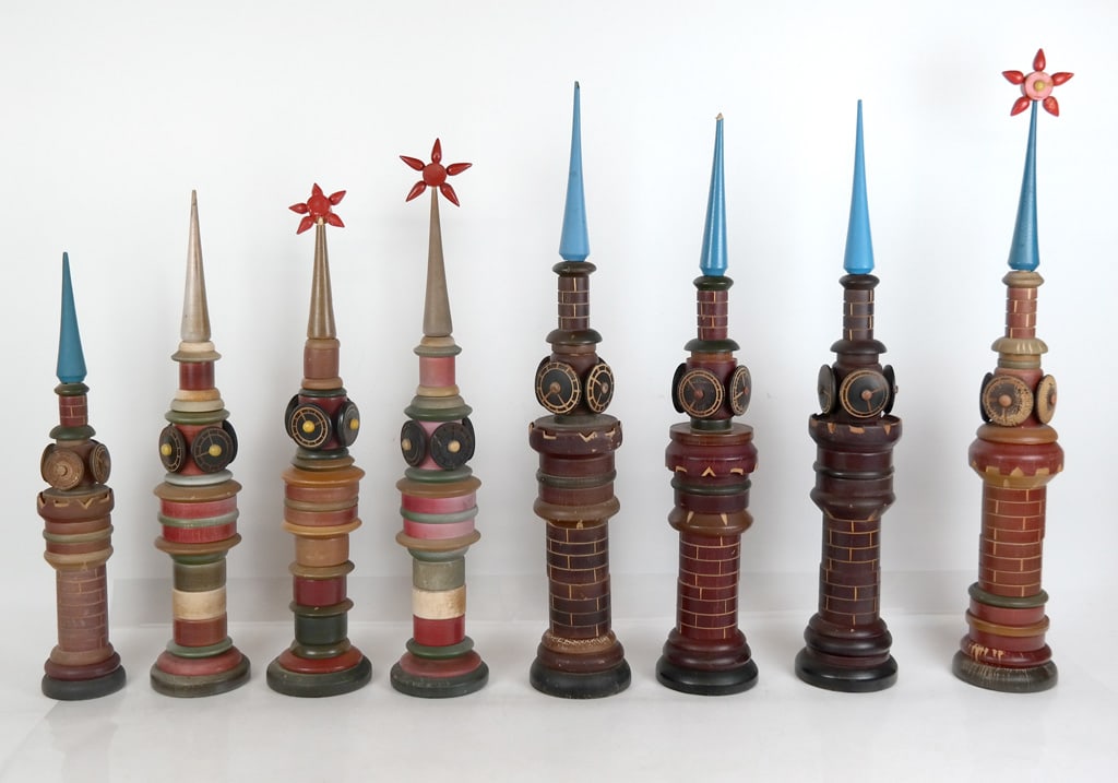 Group of Vintage Kremlin Clock Stacking Toys, 8: Group of 8 vintage Kremlin clock tower painted wood stacking toys. [Tallest: 24" H x 4" Diameter, Smallest: 17" H x 3" Diameter]. Overall condition varies, fair/good, some with stains, scratches and o