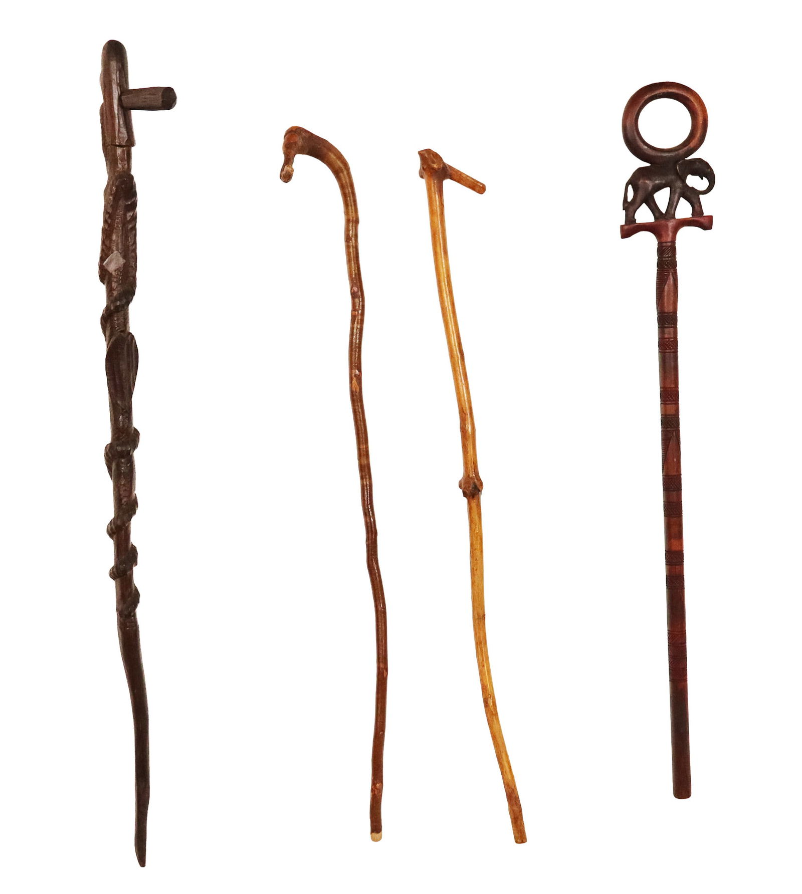 Four Assorted Walking Sticks: Four assorted walking sticks, comprising one carved with a tribal figure, two branch form sticks, and an elephant totem stick. [Largest: 40" Length].