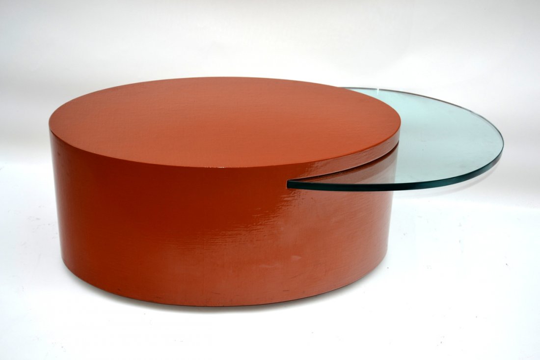 Manner of Karl Springer Cocktail Table: Orange lacquered seagrass oval top cocktail table with lower crescent shape glass tier. [45 1/2" W x 23 3/4" x 15 1/2" H]. Bears concealed caster feet. Scuffs on side.