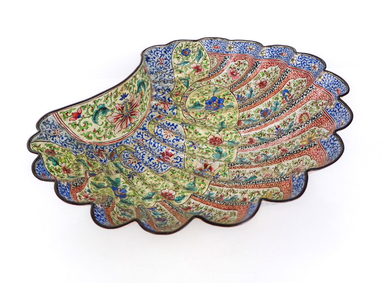 Antique Chinese Canton Enameled Bowl: Chinese Canton enameled shell shaped bowl, 19th century, with greenish tinted interior and outer blue floral rim, all over intricate floral designs of enamel on copper. [4" H x 14.5" W x 12" D]. Fair