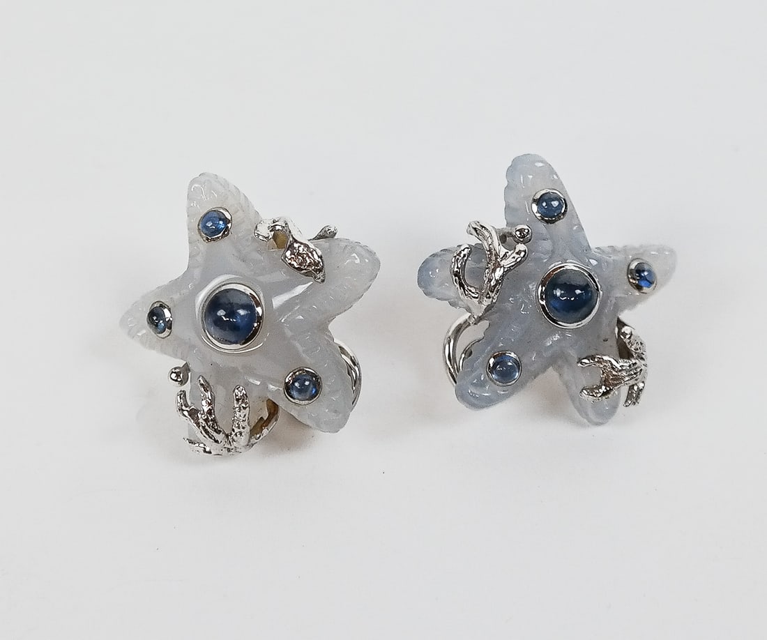 Seaman Schepps Chalcedony & Sapphire Earrings: Seaman Schepps pair of carved chalcedony, cabochon sapphire and 18K white gold starfish earrings, marked Seaman Schepps maker's mark, serial number 750. [1" Diameter]. Overall condition is very good,