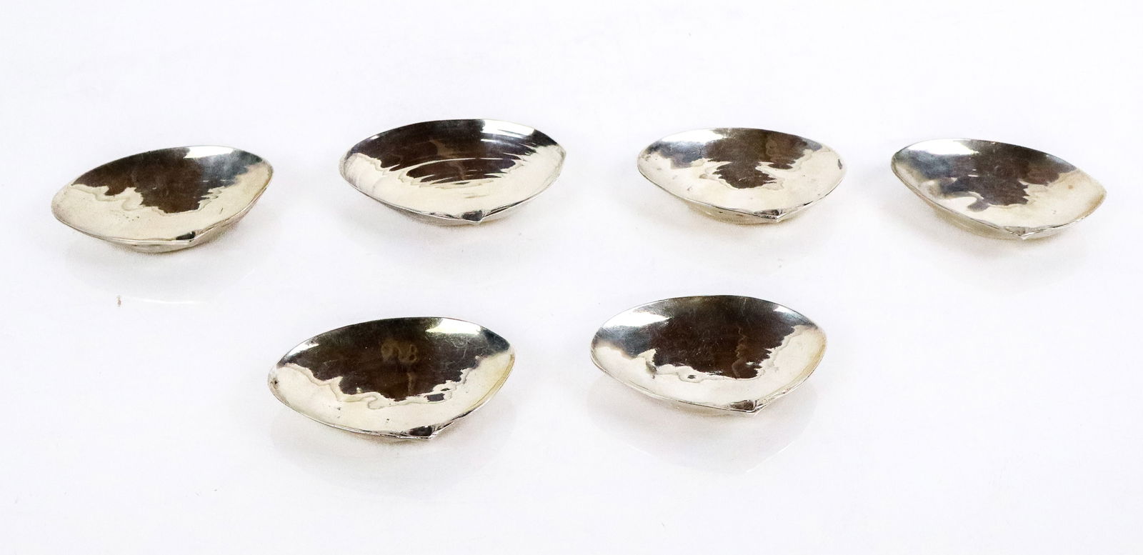 Six Sterling Silver Shell Form Individual Ashtrays: Set of six sterling silver shell form individual ashtrays, signed "Sterling". [Total 6.5 ozt., 3.5" W x 2.5" D]. Overall condition is good..