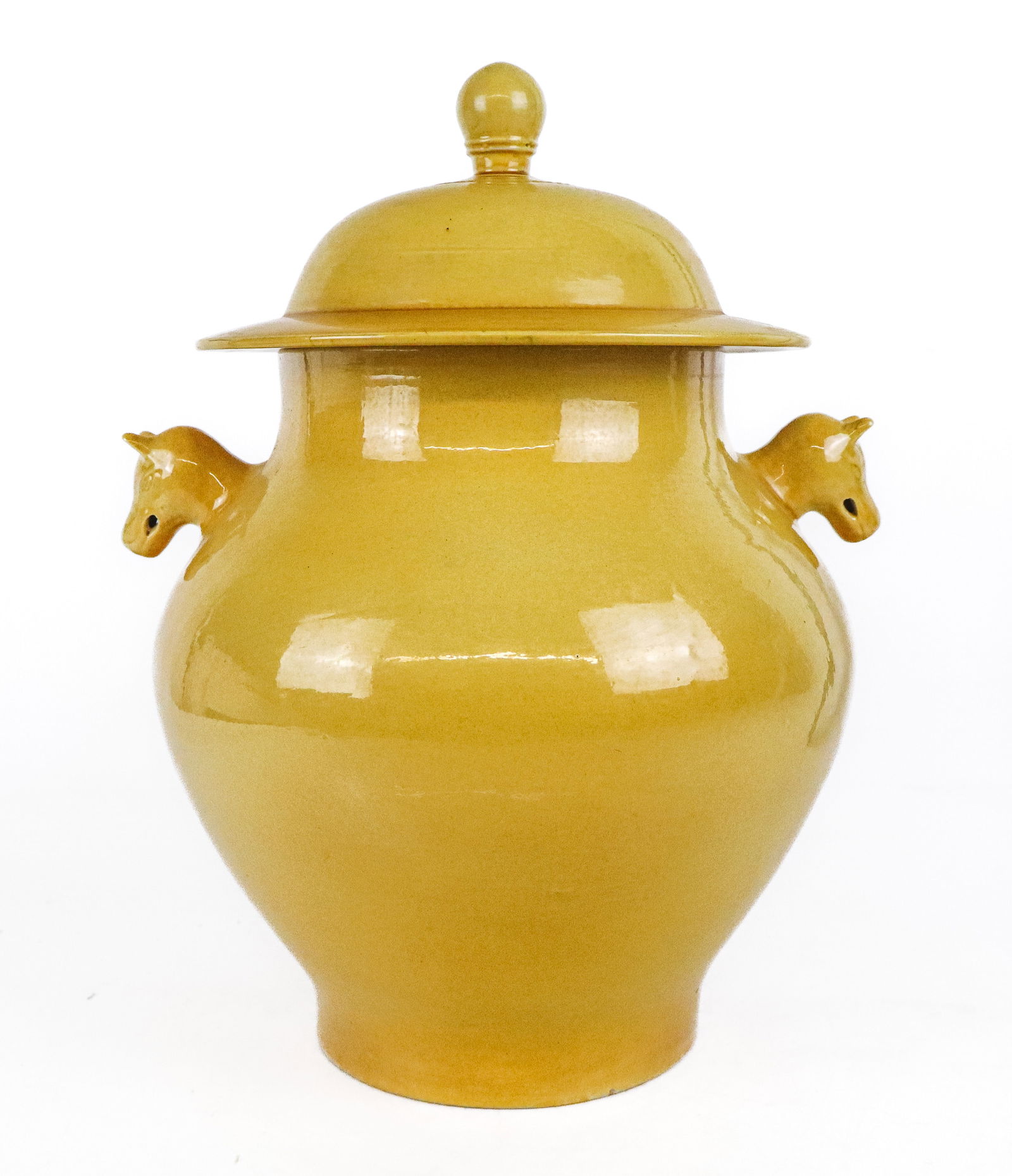 Chinese Yellow Covered Jar: Chinese yellow porcelain covered jar, 20th century, with foo dog handles and embossed decoration below the finials [14.5" H x 10" Diameter]. Good condition.