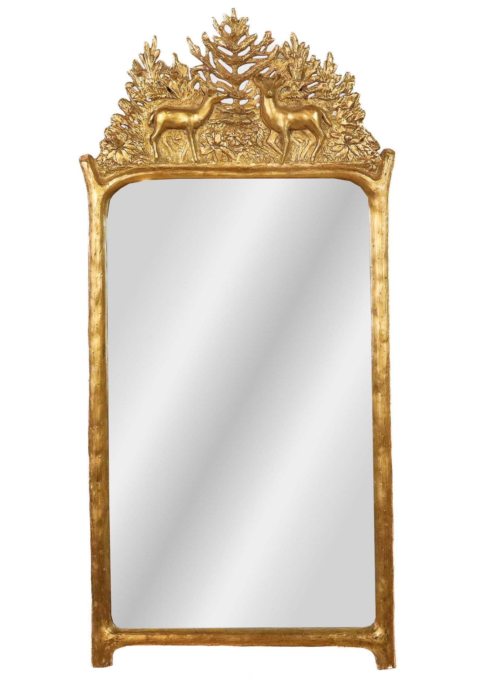 Scully & Scully Carved and Gilded Mirror: Scully & Sculy carved and gilded deer landscape mirror, late 20th century, the frame depicting two deer in a wooded landscape, retailed by Scully and Scully. [35" H x 17" W]. Good condition.