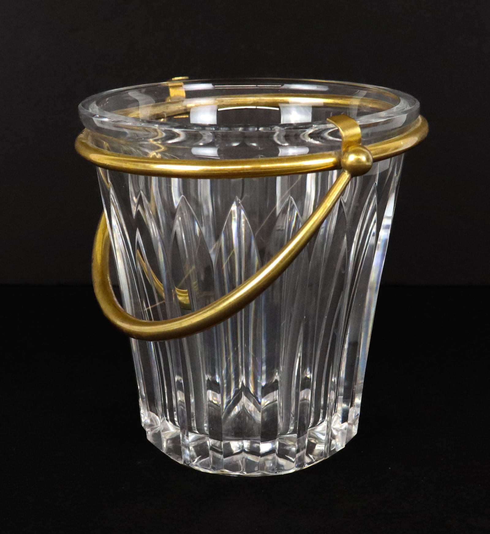 Baccarat Crystal and Brass Ice Bucket: Baccarat crystal and brass swing handle ice bucket, mark to base. [5" H x 5.5" W x 4.75" D with handle unextended]. Overall condition is good.