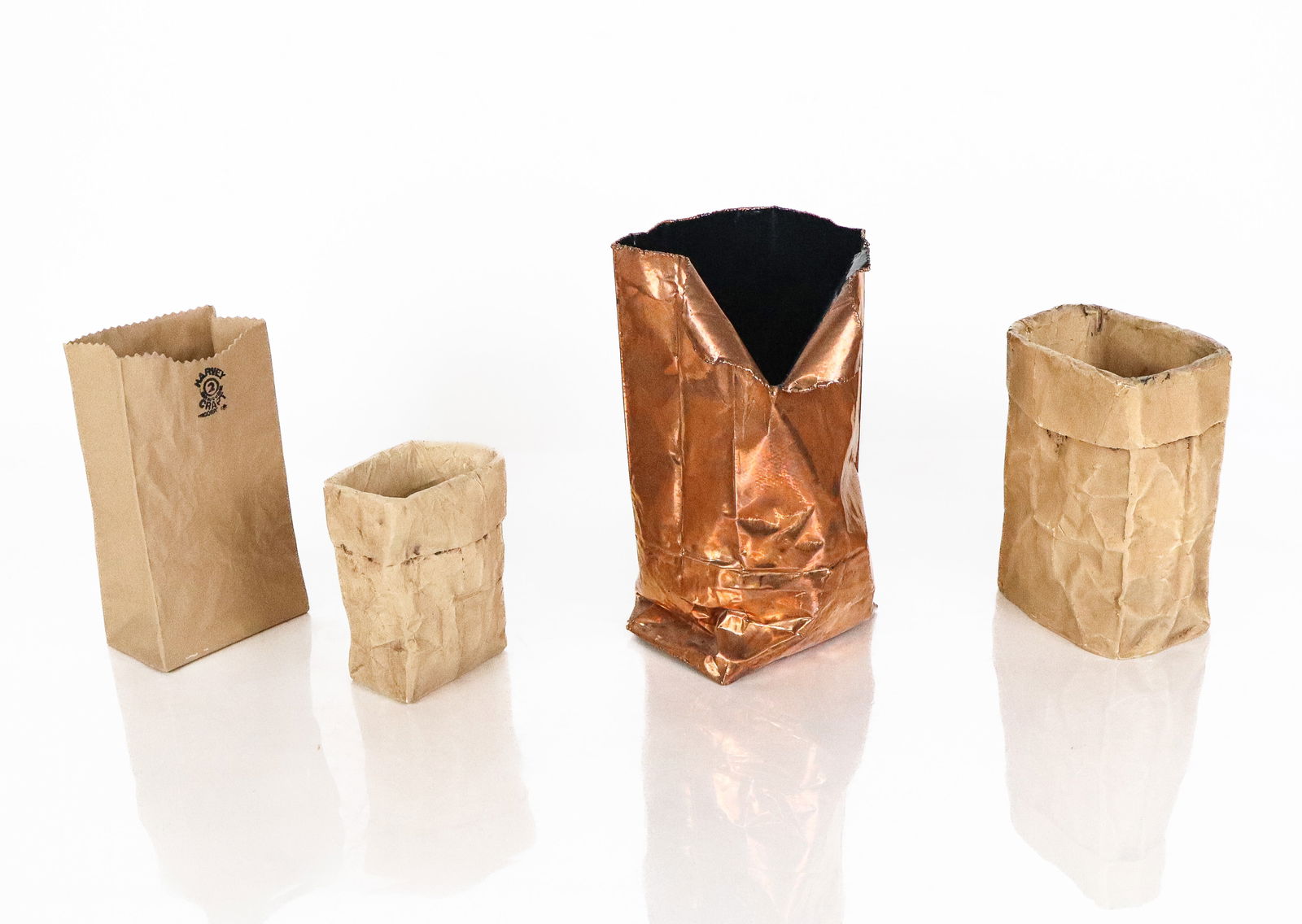 Four "Paper Bag" Planter / Sculptures: Four whimsical paper bag planters / sculptures, vases, composed of copper, and plastic, one signed Harvey Craft made in Cananda. [Tallest: 9" H x 5" W x 6" D]. Overall condition varies, mostly good, s
