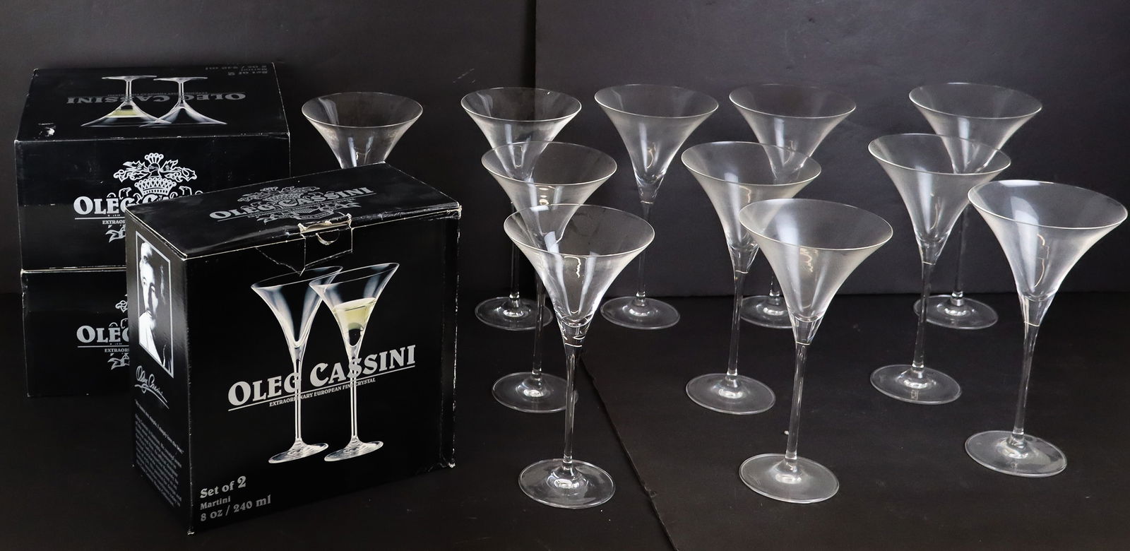 Oleg Cassini Crystal Martini Glass, 17: Oleg Cassini set of 17 crystal 8 oz. martini glasses, 3 pair boxed, signed on foot. [Glass: 9.5" H x 5" Diameter]. Overall condition is good.