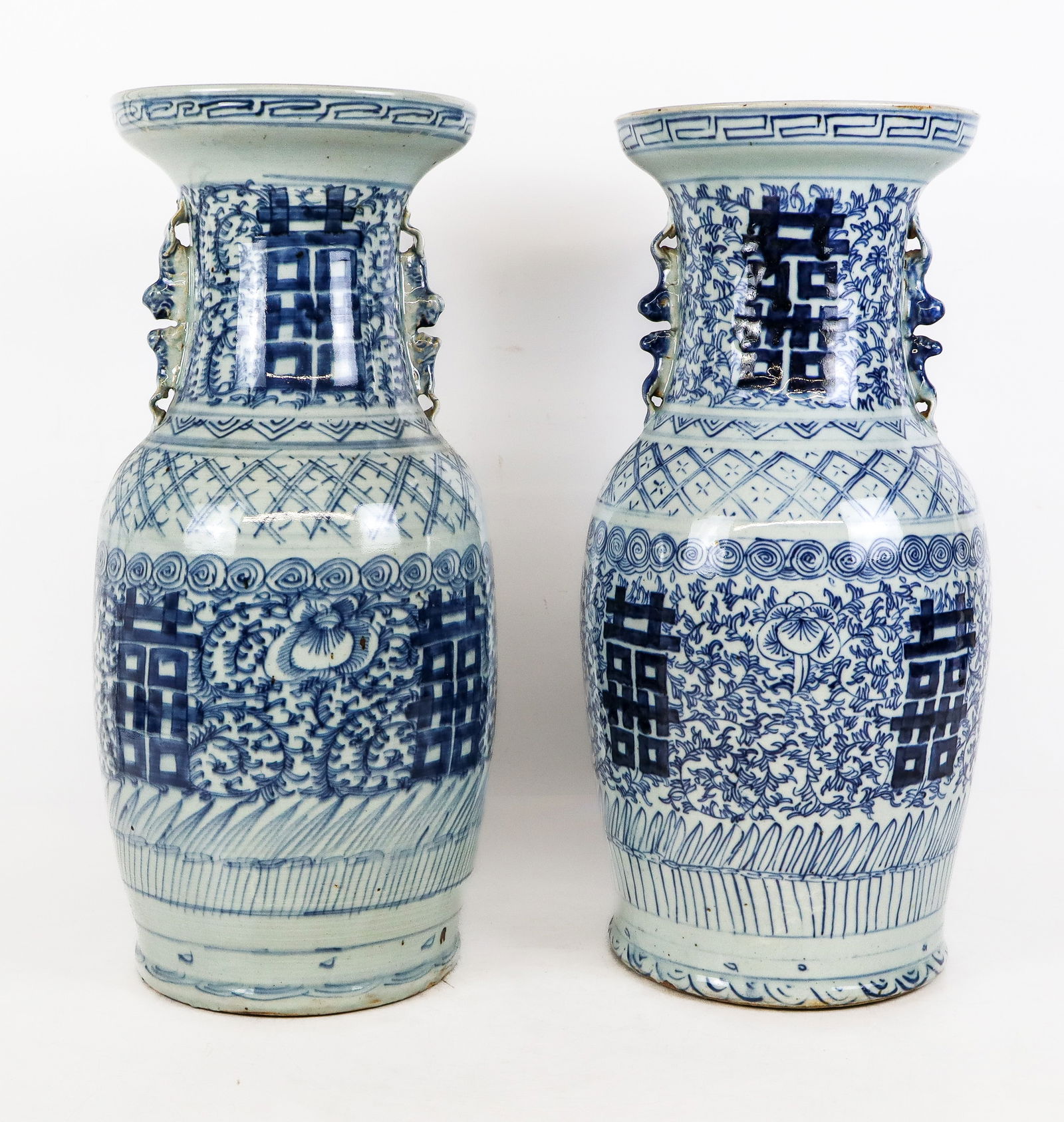Pair of Chinese Qing Dynasty Blue and White Vases: Pair of Chinese blue and white Qinghua decorated vases, Qing Dynasty, circa 1900, with all over scrolled foliate and double happiness decoration, and two handles to upper, with Chinese export seals