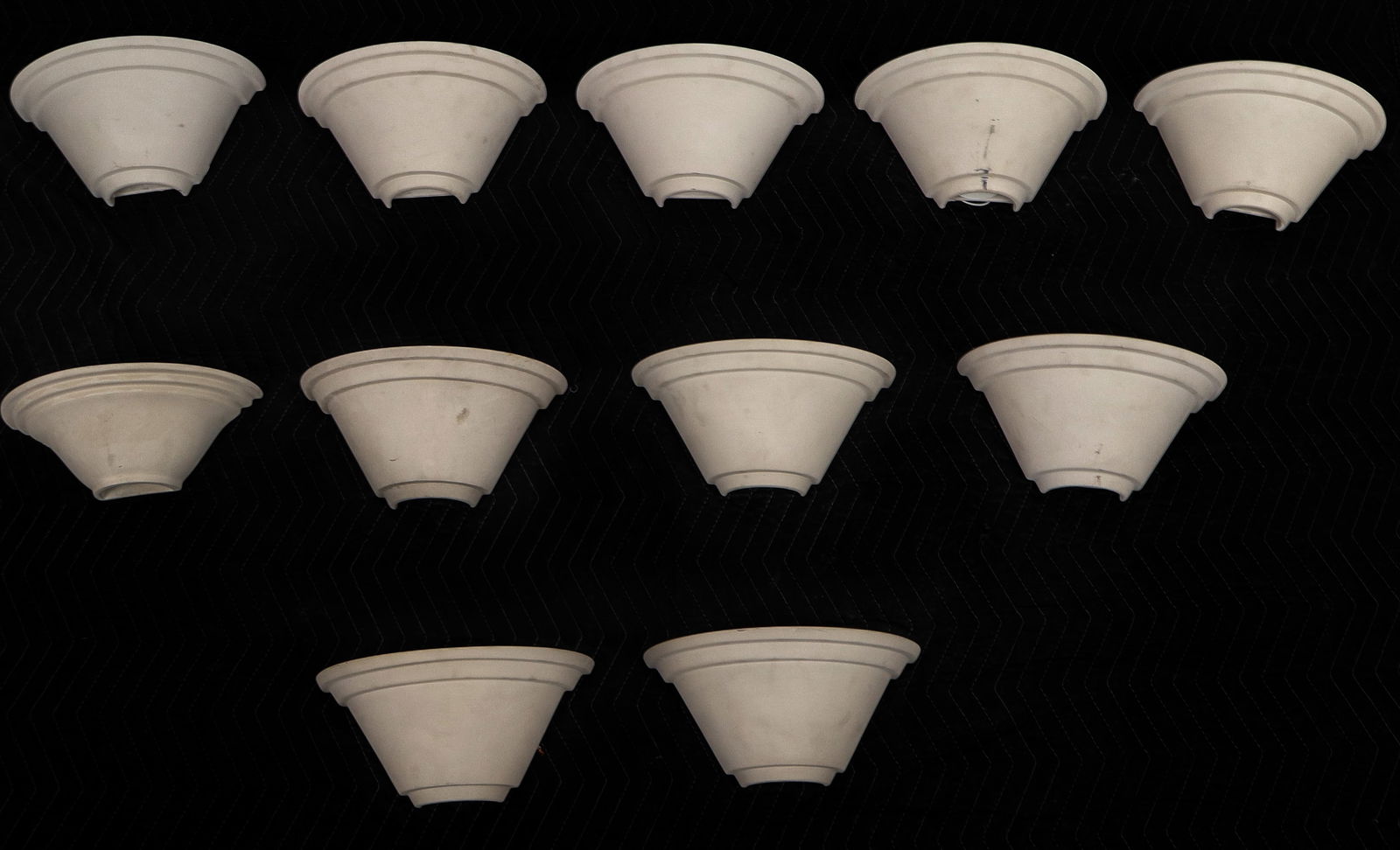 Large Group of Bisque Porcelain Sconces, 11: Large group of bisque porcelain sconces, 20th century, in a demilune form, marked "Faddy" to reverse. [7.5" H x 12" W x 6.5" D]. Condition is good with some surface wear.