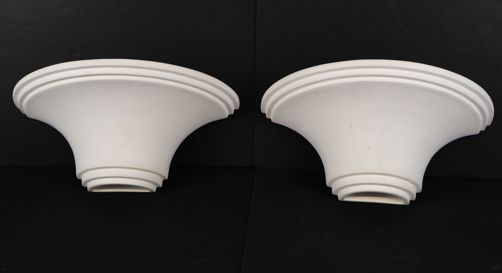 Two Bisque Porcelain Sconces: Two bisque porcelain sconces, 20th century, in a flared demilune form, marked "Faddy" to reverse. [8" H x 14.5" W x 8" D]. Condition is good with some surface wear.