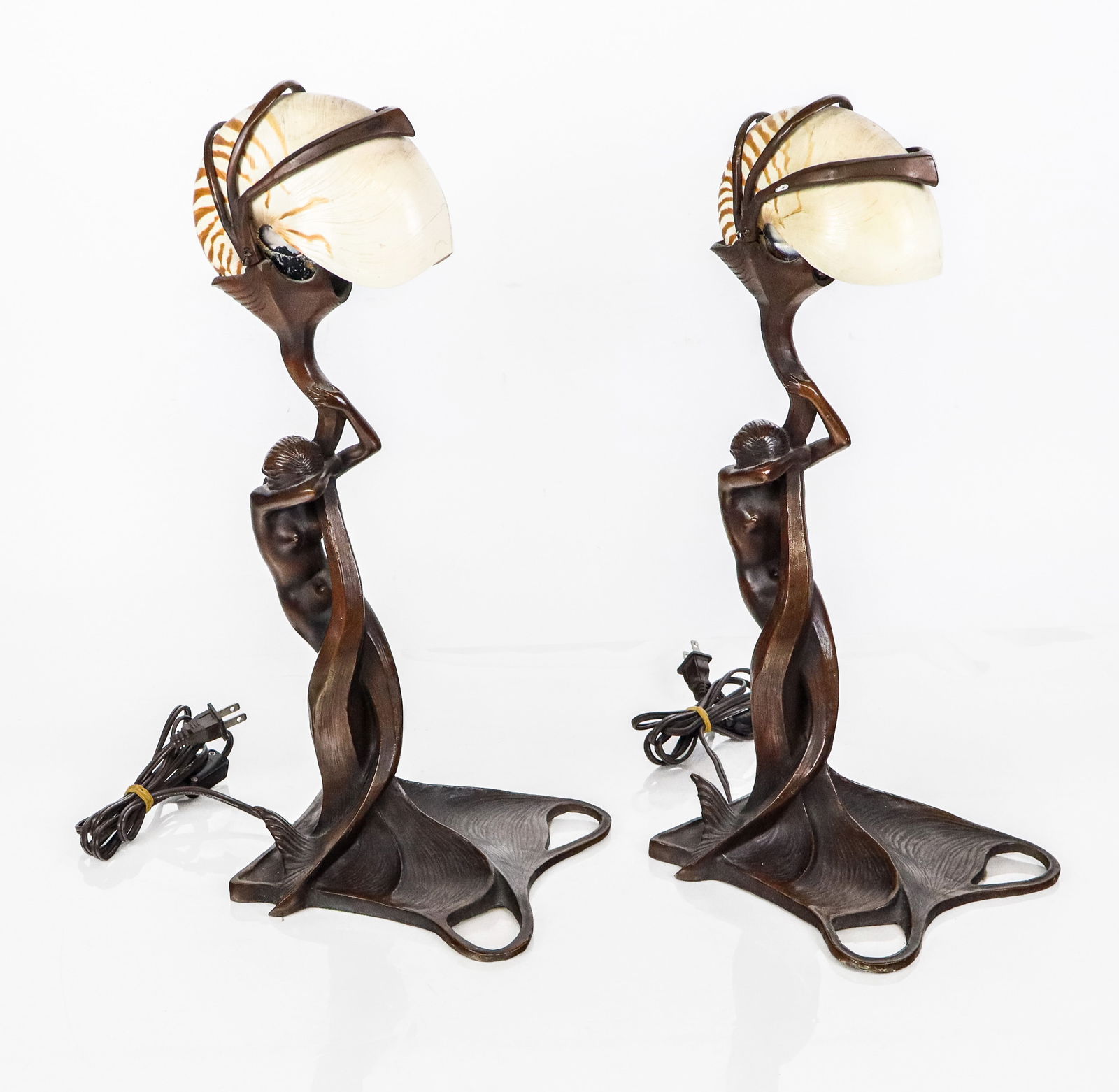Gustav GURSCHNER Bronze Table Lamps, Two: Two Art Nouveau bronze mermaid form table lamps with nautilus shell shades, After Gustav Gurschner, unsigned. [19" H x 7.5" W x 7.5" D]. Condition to each is good with some minor wear.