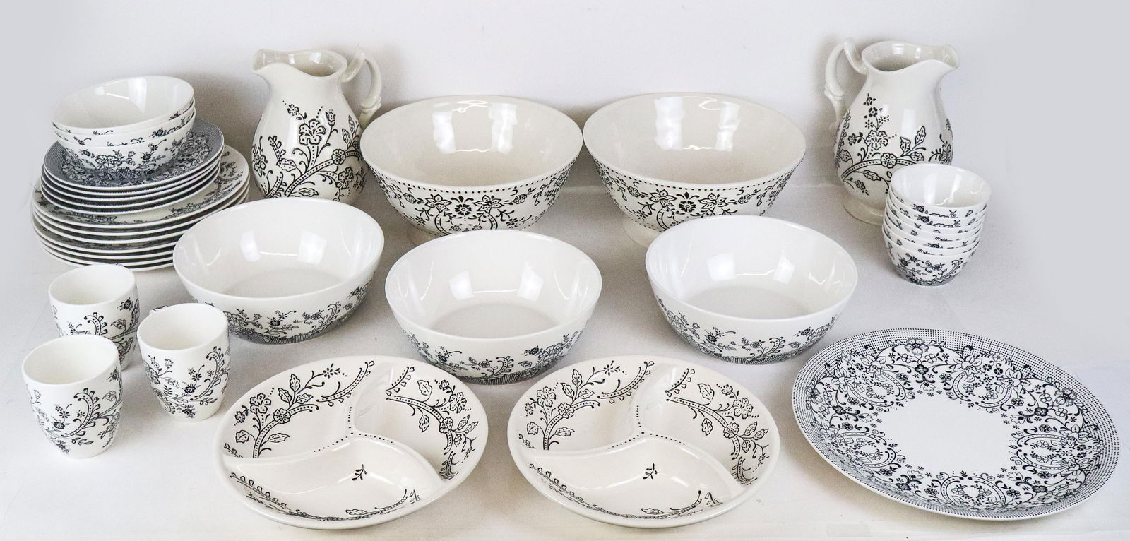 Oleg Cassini "Ava" Ceramic Service, 35: Oleg Cassini "Ava" pattern of off-white and black porcelain table service, comprising a pair of large footed bowls [5" H x 11" Diameter], a pair of water pitchers [9.5" H x 7.5" W x 6" D], a set of