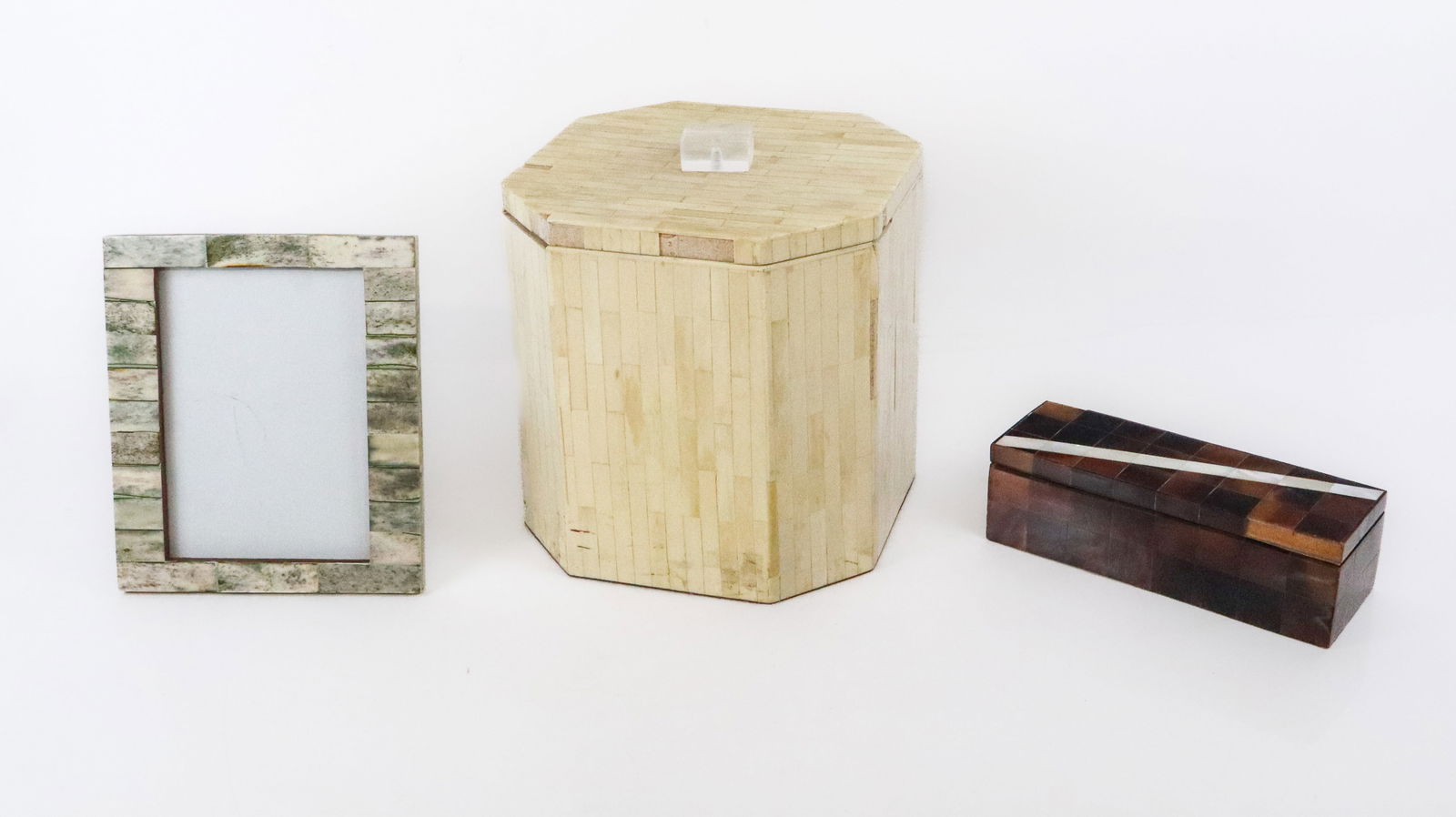 Three Bone & Faux Bone Veneered Objects: Three bone and faux bone veneered objects, comprising an octagonal ice bucket [8.5" H x 8.5" Square], a pen / trinket box with mother-of-pearl strip, and an easel back picture frame [8" H x 6.75" W].