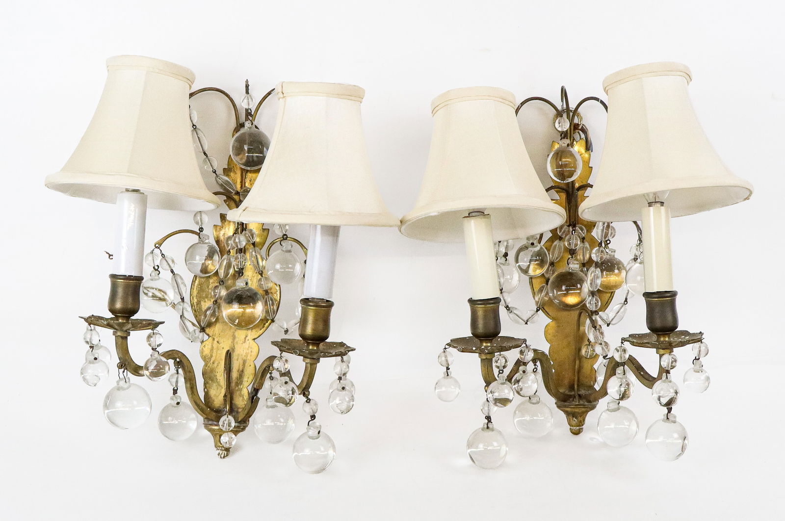 Pair of Mid-Century Modern Sconces: Pair of brass 2 arm sconces with crystal ball drops and ball form chains. [12" H x 9" W x 5" D]. Good condition, may be a missing drop or 2.