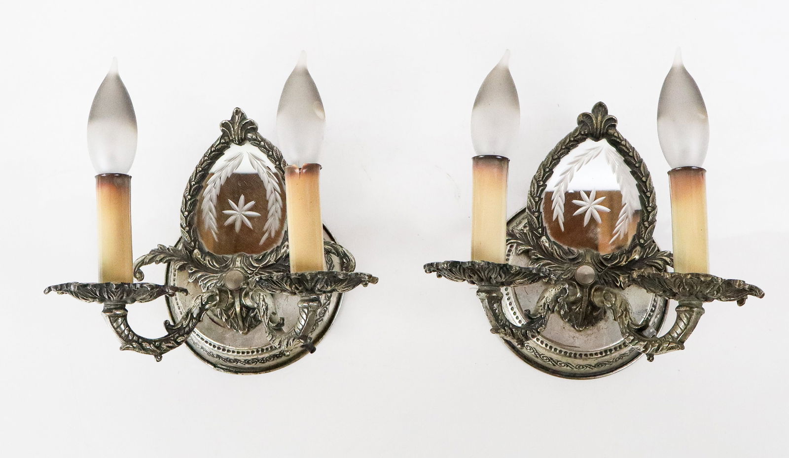 Pair of Hollywood Regency Small Sconces: Pair of Hollywood Regency 2 arm sconces in white metal, with small etched mirror mounts, loose backplate. [9" H x 8" W x 6" D]. Good condition, loose backplates.