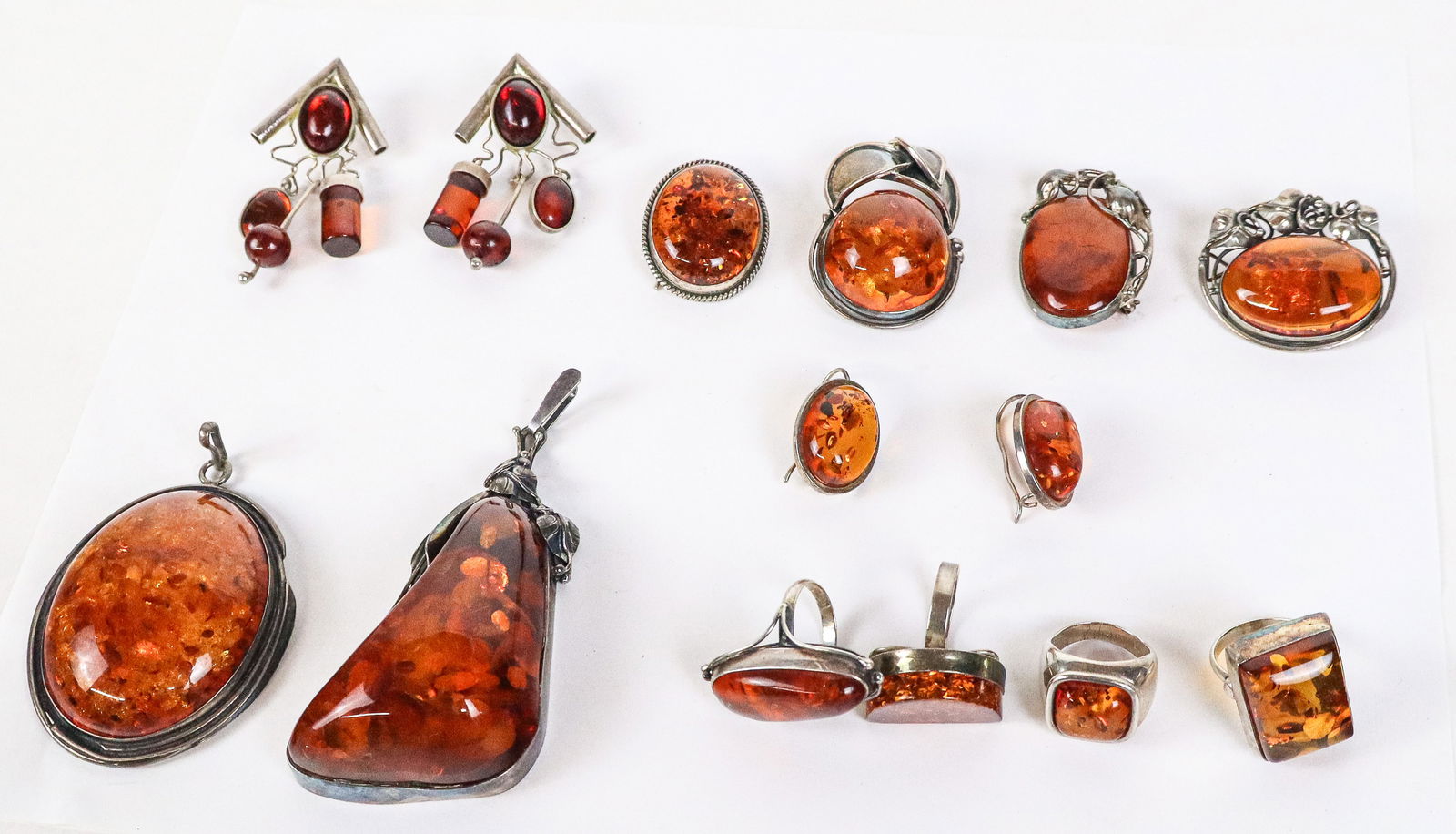Collection of Silver and Amber Jewelry, 14: Collection of silver and amber jewelry, comprising 4 rings, 3 pendants, 3 brooches, and 2 pair of earrings, only 1 marked 925, all test for silver. [Largest oval cabochon pendant excluding bail: 2.5"