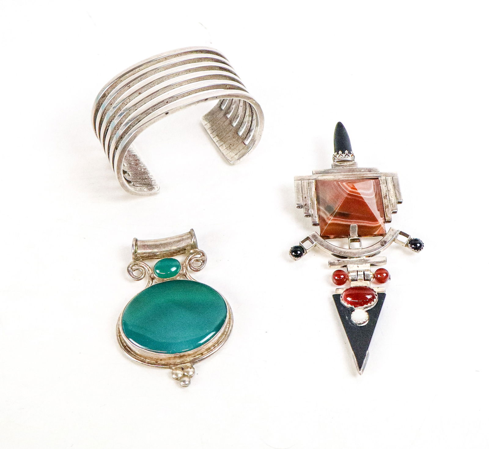 Michel Plumail, Tricia's & Other Silver Jewelry, 3: Collection of sterling silver jewelry, comprising a Michel Plumail cuff bracelet [5" Interior circumference excluding the 125" break], Tricia's chalcedony pin pendant [5" H x 2.25" W], and a green aga