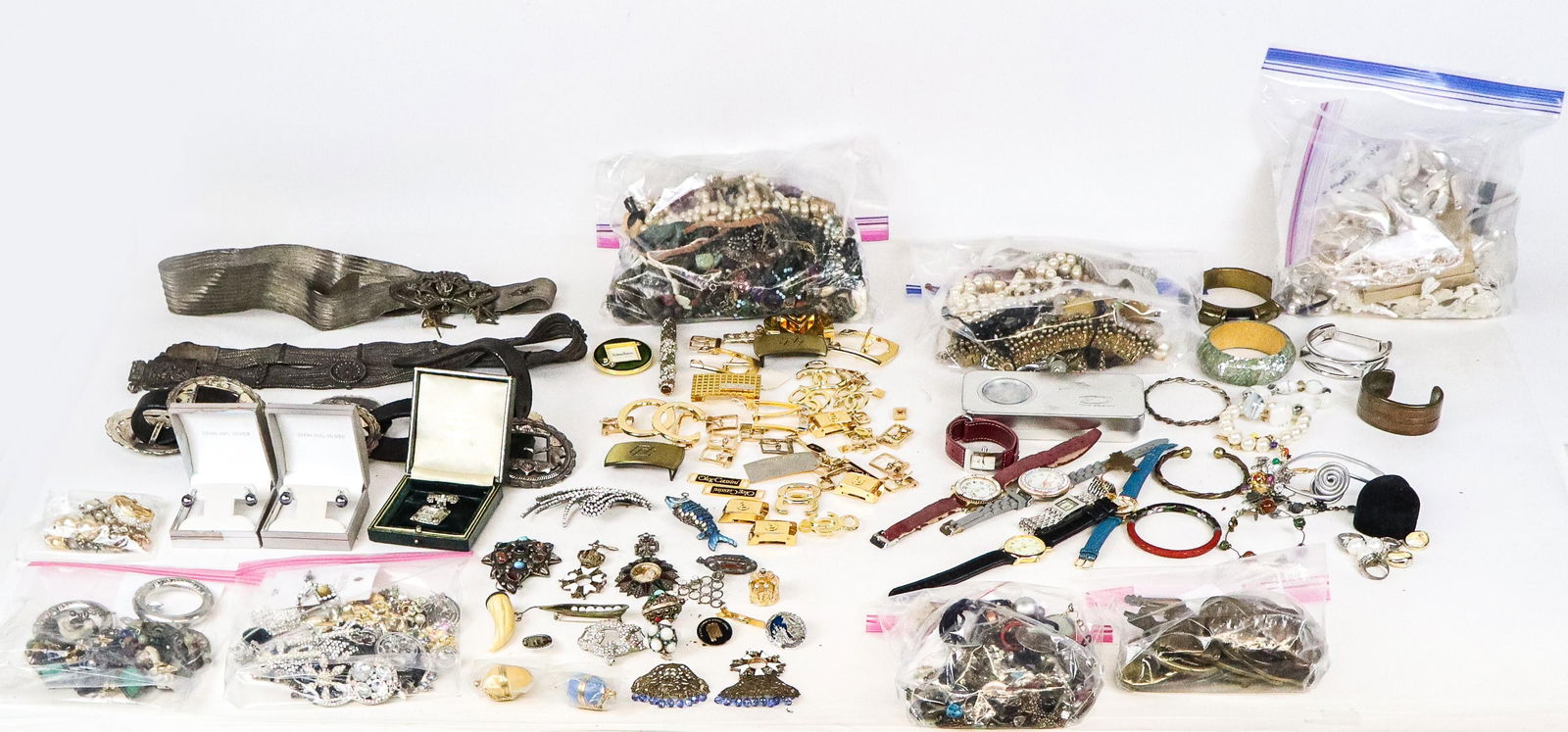 Large Group of Costume Jewelry, 100+: Large group of costume jewelry, comprising brooches, pendants, necklaces, group of 7 vintage brass belt buckles, one metal belt buckle, large group of 30+ Oleg Cassini gilt metal clasps, watch and bel