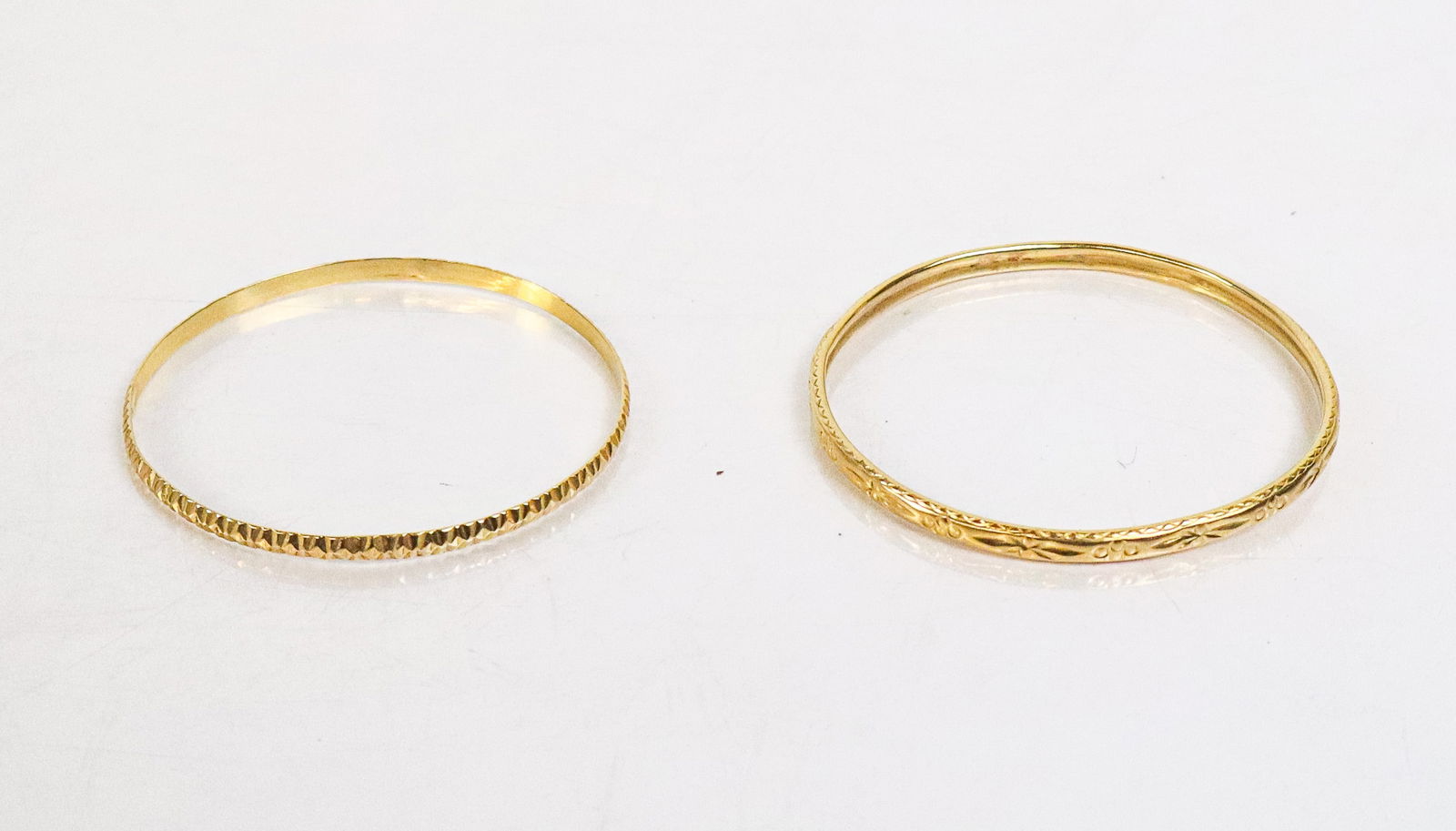 Two High Carat Gold Bangle Bracelets: Two high carat gold bangle bracelets, one marked 22K, the other tests for 22K. [Total 13.35 dwt.]. Overall condition good, bent.
