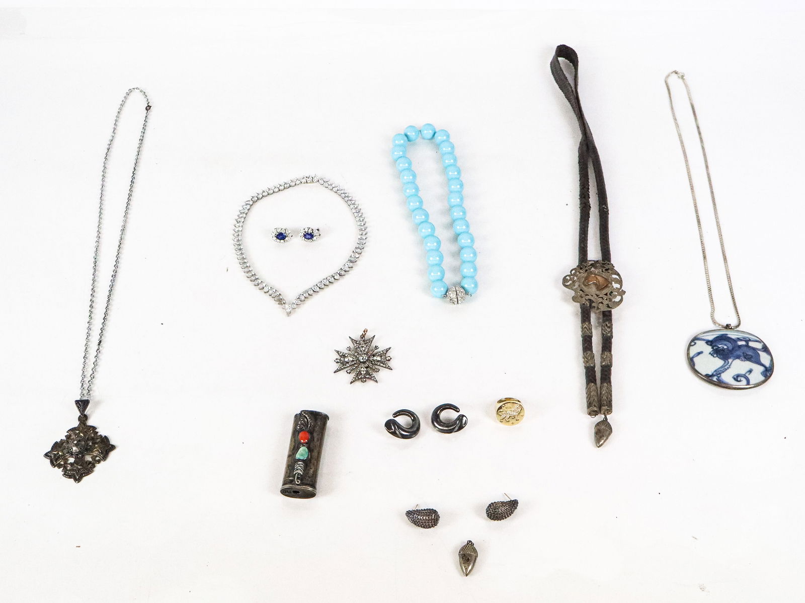 Group of Costume and Silver Jewelry, 14: Assorted group of costume and silver jewelry, comprising a faux turquoise bead necklace, a faux diamond necklace, a pair of faux sapphire and faux diamond earrings, a paste Maltese cross pendant, cost