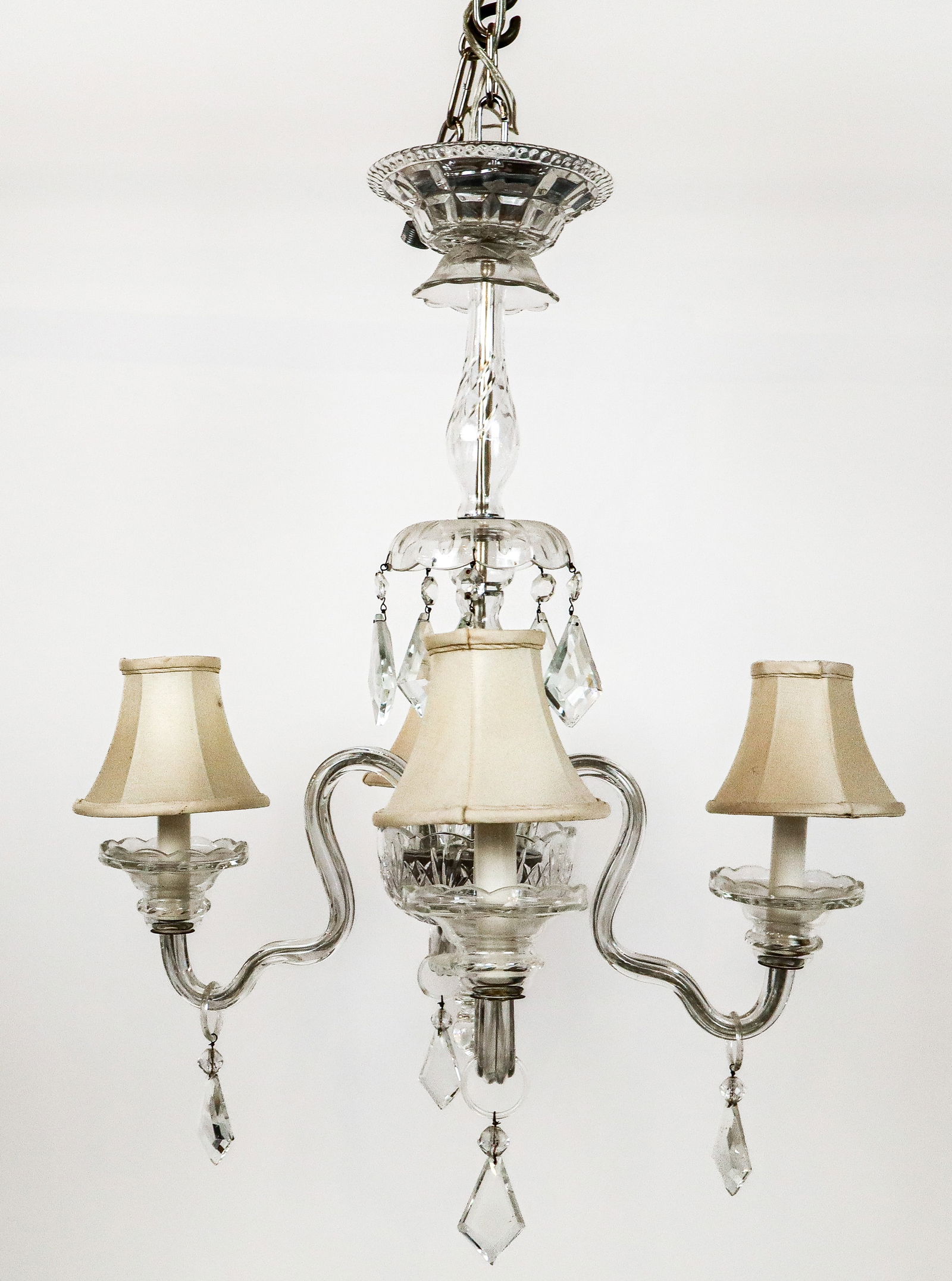 Crystal Four-Light Chandelier: Crystal four-light chandelier, 20th century, with etched details and faceted lustres and girandole arms. [26" H x 20" Diameter]. Condition is good with some minor fleabites, loss at lower stem, and a