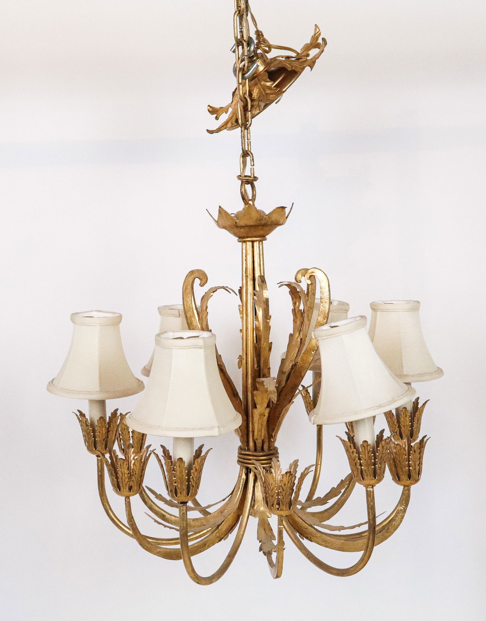 Hollywood Regency Gilt Six-Light Chandelier: Hollywood Regency gilt chandelier, 20th century, with gilt foliate decoration, and twelves arms, with six alternating lights. [Including chain:: 35" H x 20" Diameter]. Condition is good; wiring untest