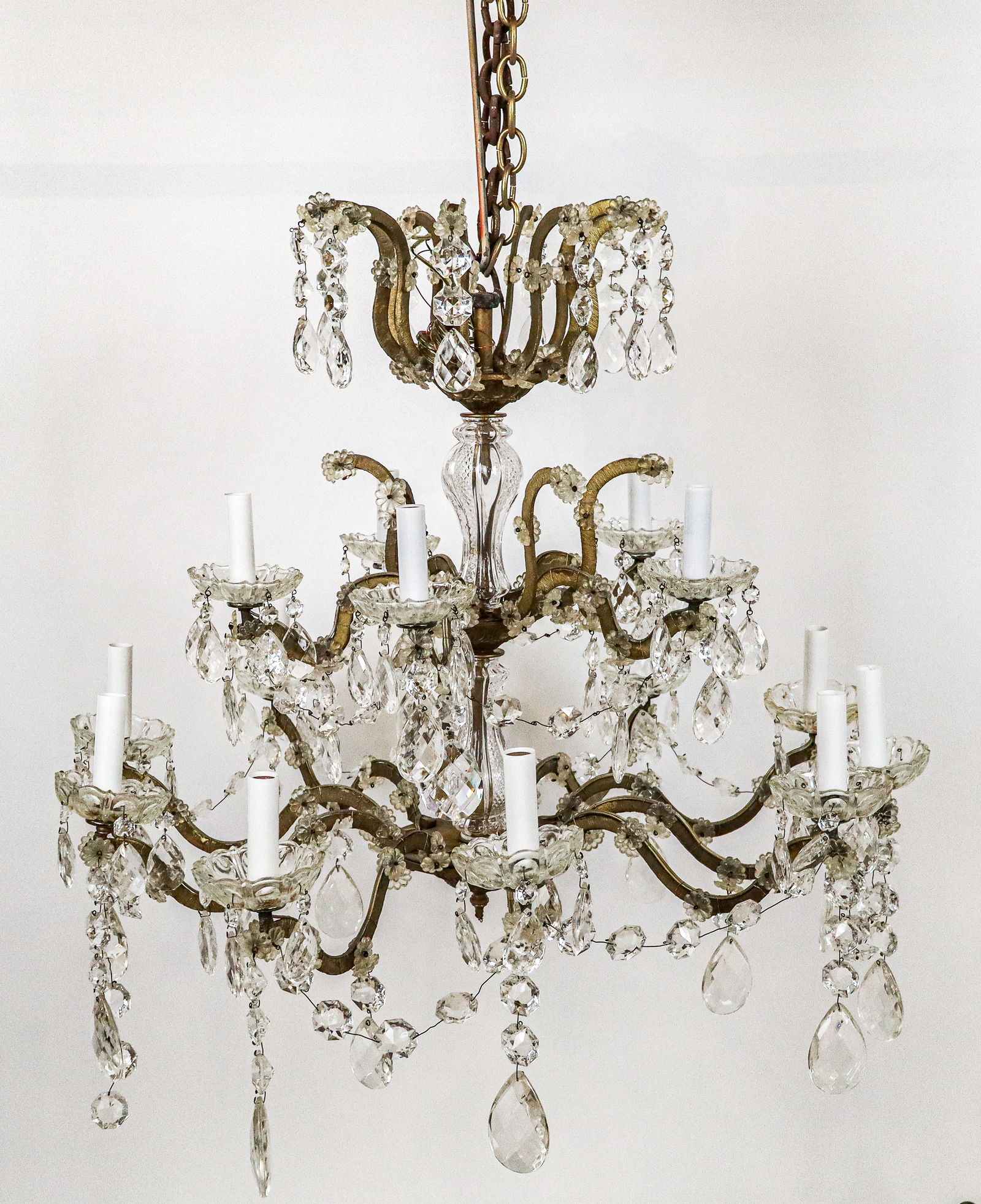 Gilt Bronze and Cut Crystal Two-Tier Chandelier: Gilt bronze and cut crystal two-tier chandelier, 20th century, with floral and faceted crystal decoration and fifteen lights. [36" H x 30" Diameter]. Condition is good with one crystal swag partially