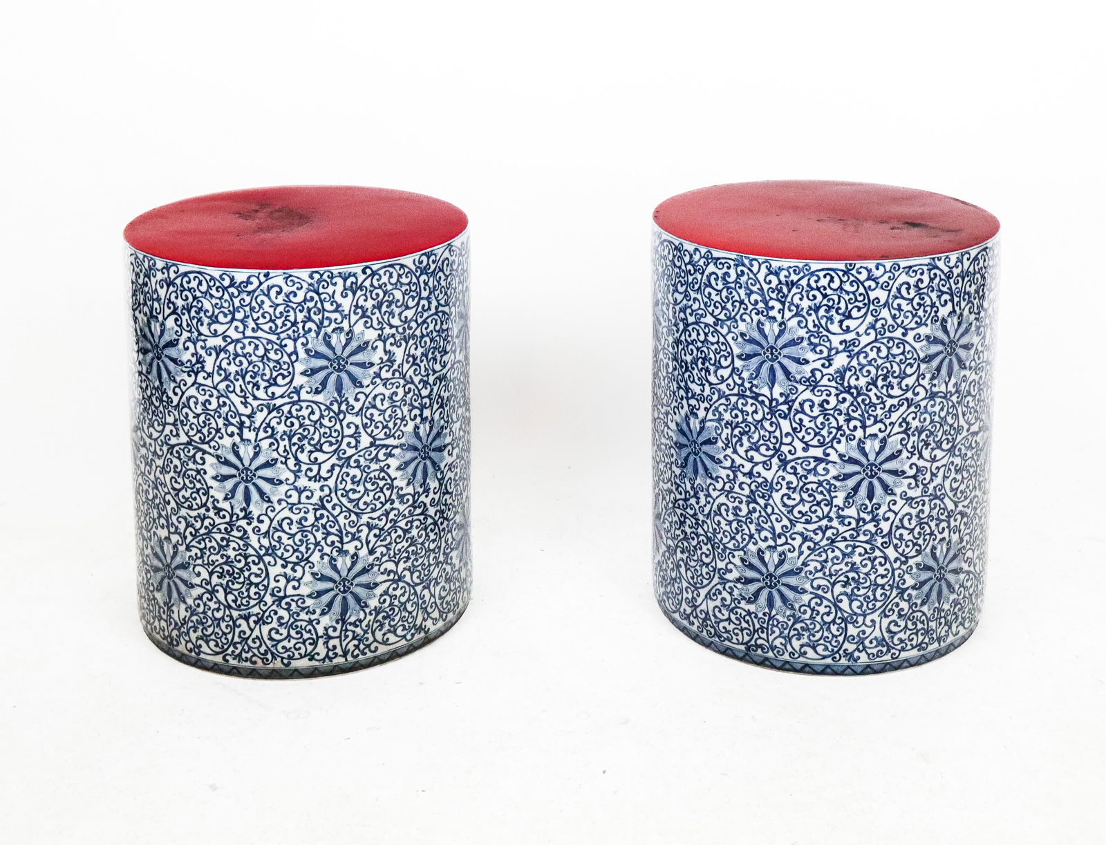 Pair Gump's Porcelain Blue and White Garden Seats: Pair of Gump's porcelain blue and white garden seats, 20th Century, with blue and white decorated sides and red seats, each stamped Gump's to underside. [18.5" H x 15" Diameter]. Condition to each is