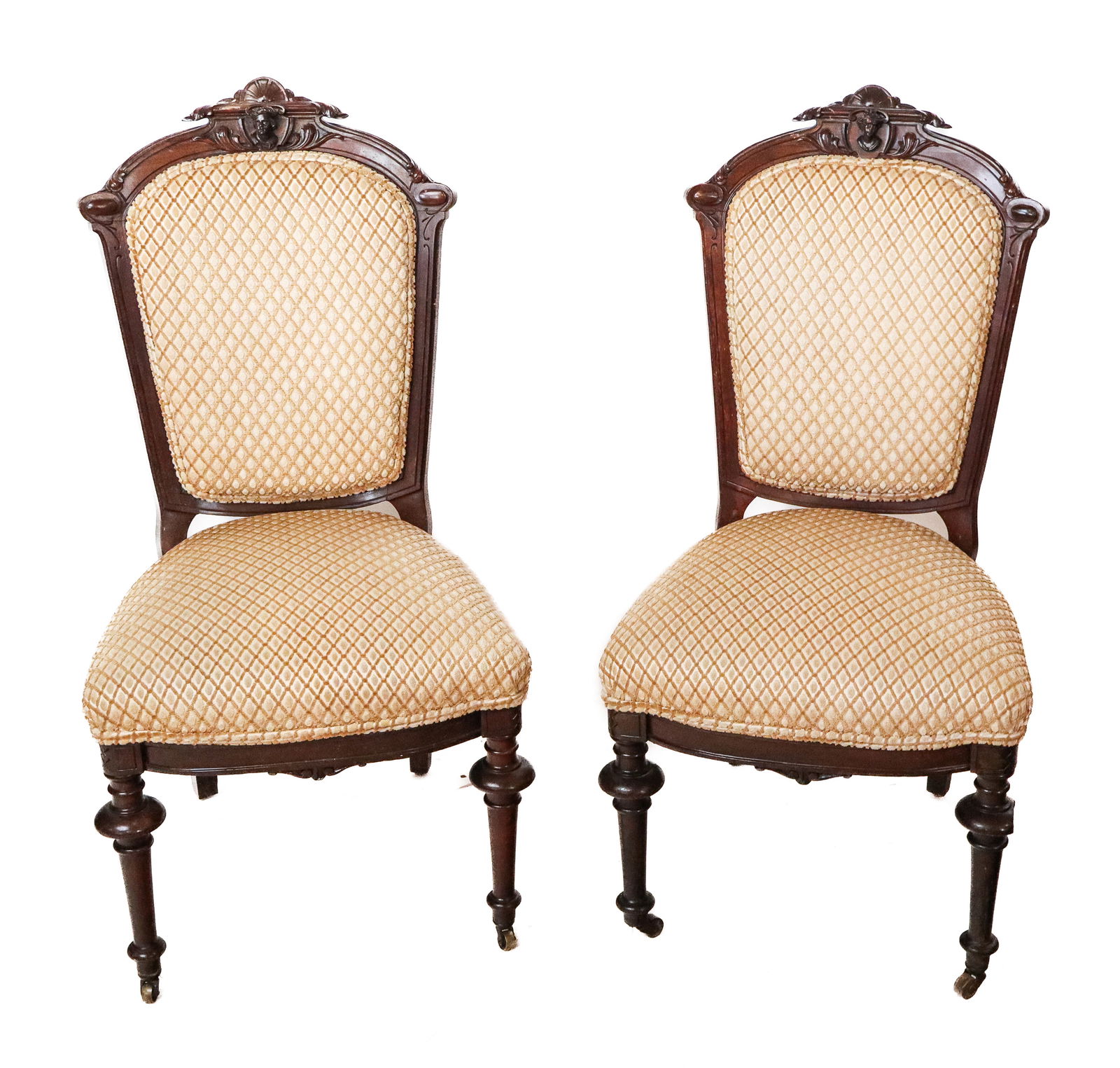 Pair of Victorian Carved Wood Chairs: Pair of Victorian carved wood chairs, American, 19th century, with carved wood frames and complimentary allegorical carvings to crest rails, and two turned wood legs on castors. [40" H x 20" W x 20" D