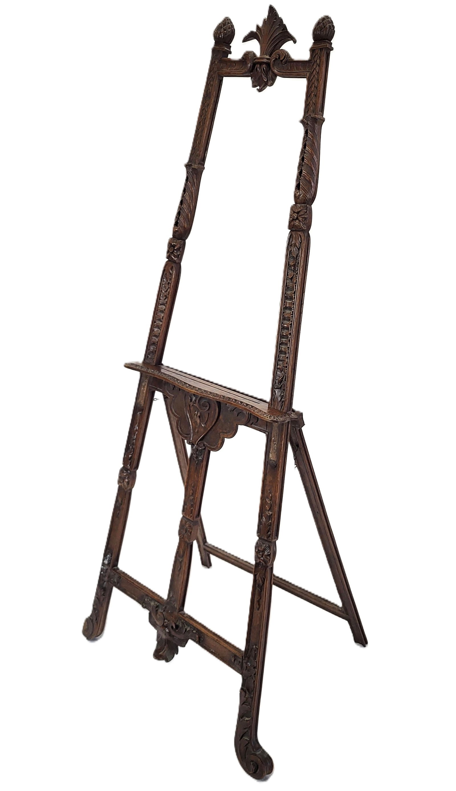 French Highly Carved Painting Easel: French highly carved painting easel, acorn and fleur finials and highly carved sectioned post, gadrooned shelf holder, scrolling legs. [62" H x 27" W x 14"]. Some losses on carving.