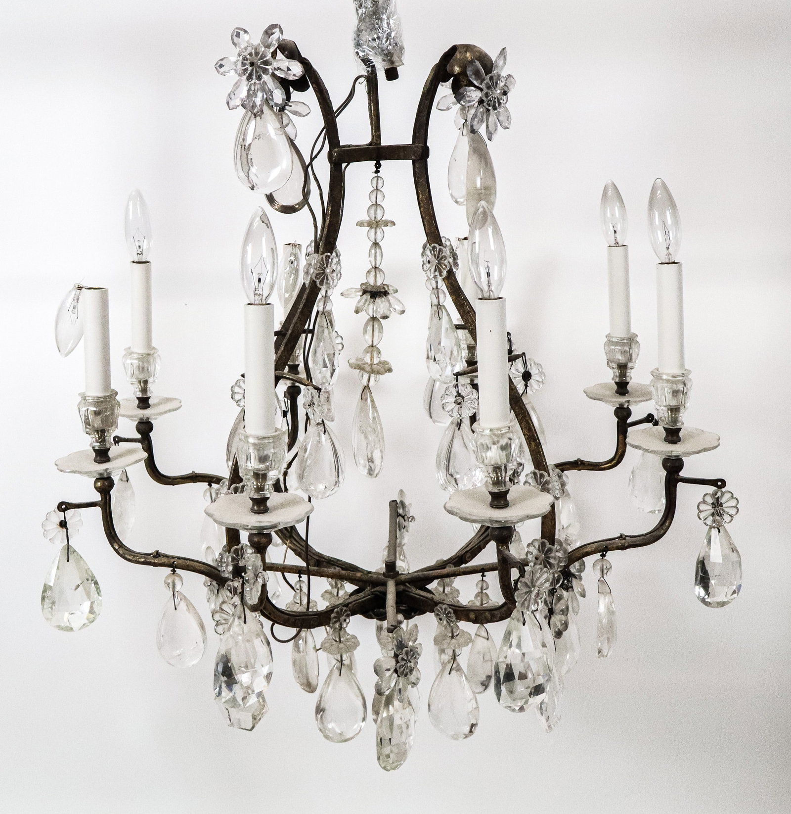 French Rock Crystal and Gilt Iron Chandelier: French Rock Crystal and gilt iron 8 arm chandelier, Rock and simple pear shaped large crystals about a gilt iron chandelier with 8 lights, some crystal buttons, and a peach shaped bottom drop crystal.