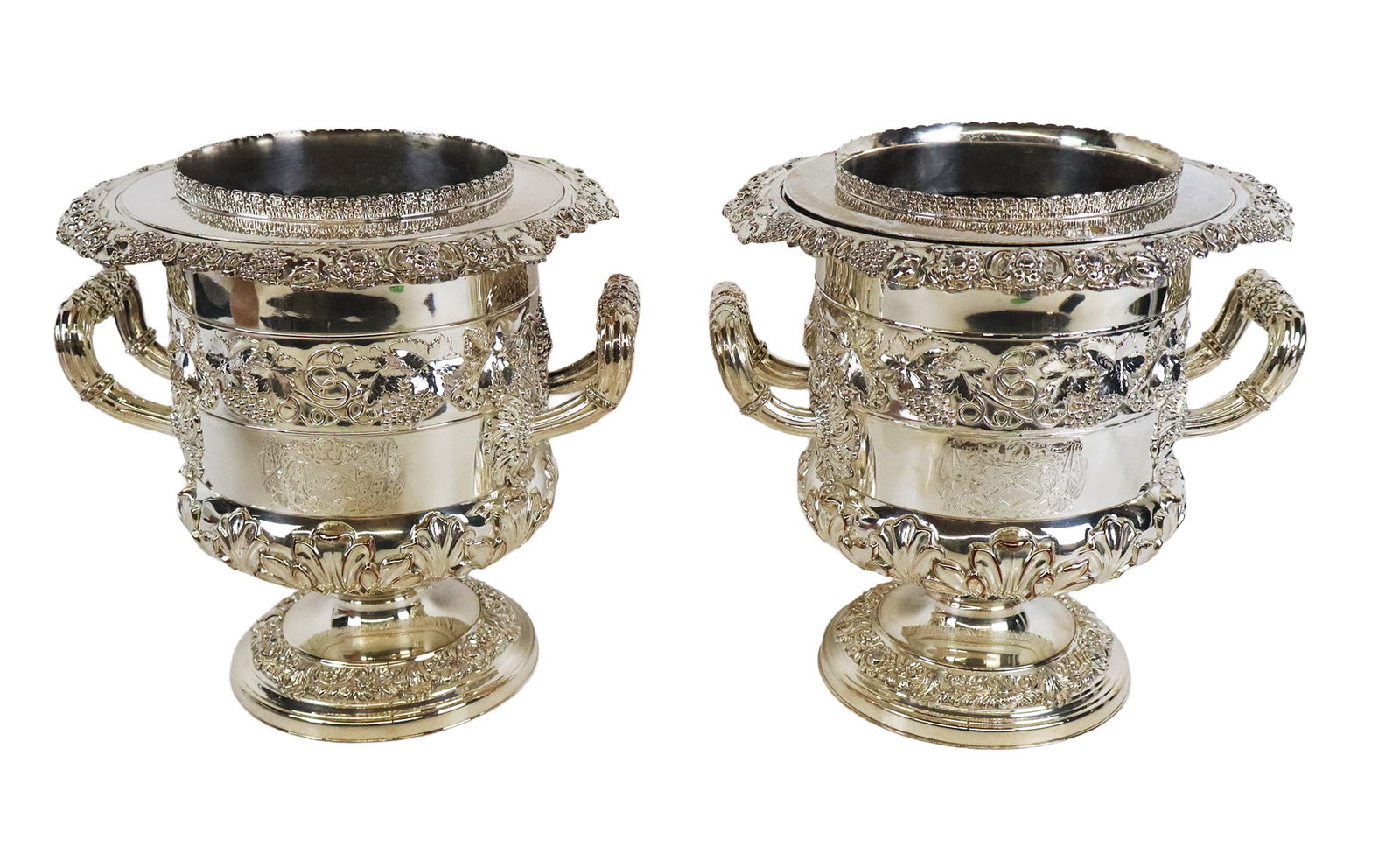 Pair of Silver Plate Wine Coolers: Pair of silver plate elaborately decorated double handled wine coolers with bands of grape clusters, anthemion's, and crest.[9.5" H x 9" W x 9.5" D]. Overall condition is good, one slightly bent, wear