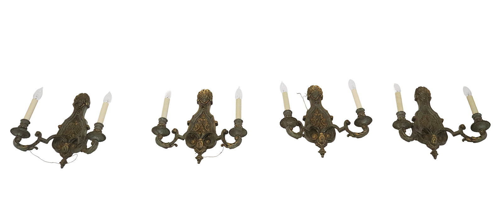 Set of Four Cast Iron French Regence Sconces: Set of four cast iron French Regence sconces, female face and shell pediments above sculpted and scrolling backplates, two scrolling arms each, painted and partially gilt. [15" H x 14" W x 5" D]. Good