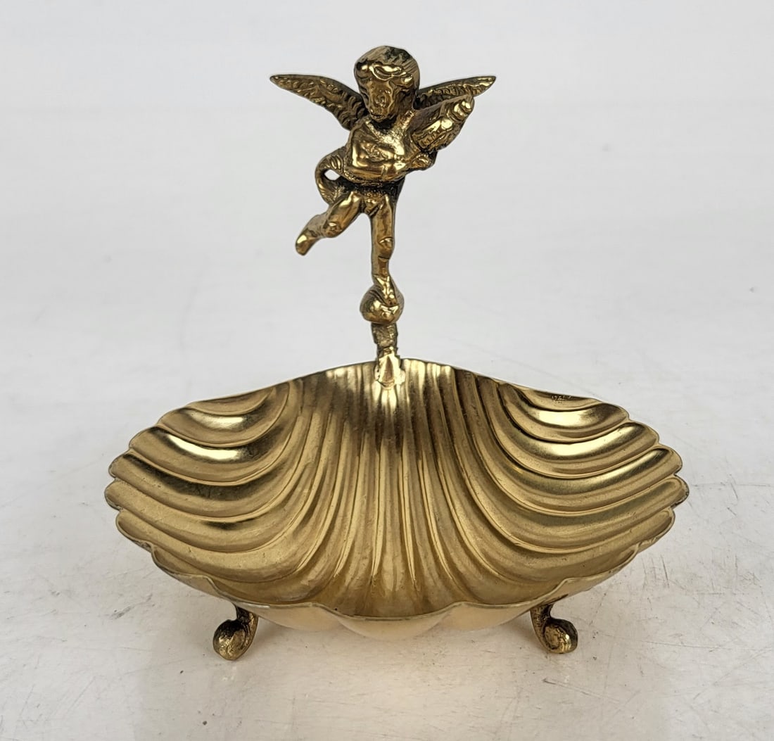 Gilt Metal Dish with Cherub: Gilt metal shell-form dish with Cupid figure, on three legs. [3 3/4" H x 3 1/4" W x 3 3/4" D]. In good condition, with no losses. Condition reports and requests for additional photos cannot be accepte