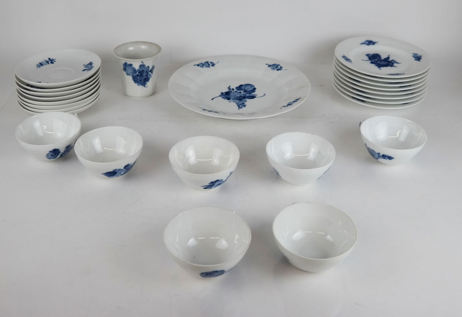 Group of Royal Copenhagen "Blue Flowers" Porcelain: Group of Danish Royal Copenhagen "Blue Flowers" porcelain, comprising a dinner plate [10" H x 1 1/4" W], 8 saucers and 7 cups [Saucer: 5 3/4" Diam.], 8 dessert plates [7" Diam.], and 1 small urn [3 1/