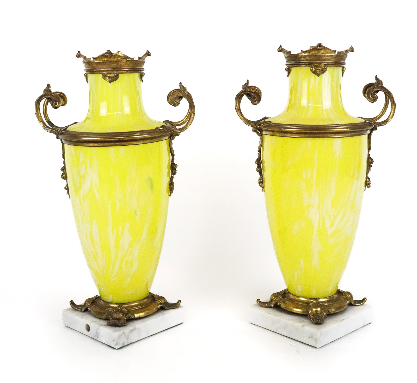 Pair of Bronze Mounted Yellow Glass Urns: Pair of Venetian style yellow and white glass urns with gilt bronze mounts, resting on marble bases. [12.5" H x 7" W x 5" D]. Overall condition is good/fair, with discoloration to metal, urns drilled